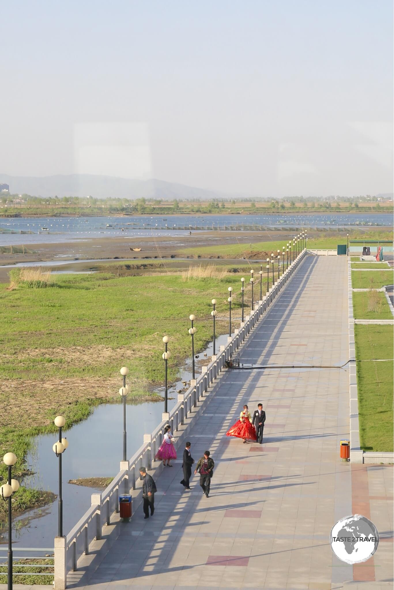 Our first view of North Korea - the spotlessly clean promenade on the banks of the Yalu river - opposite Dandong, China.