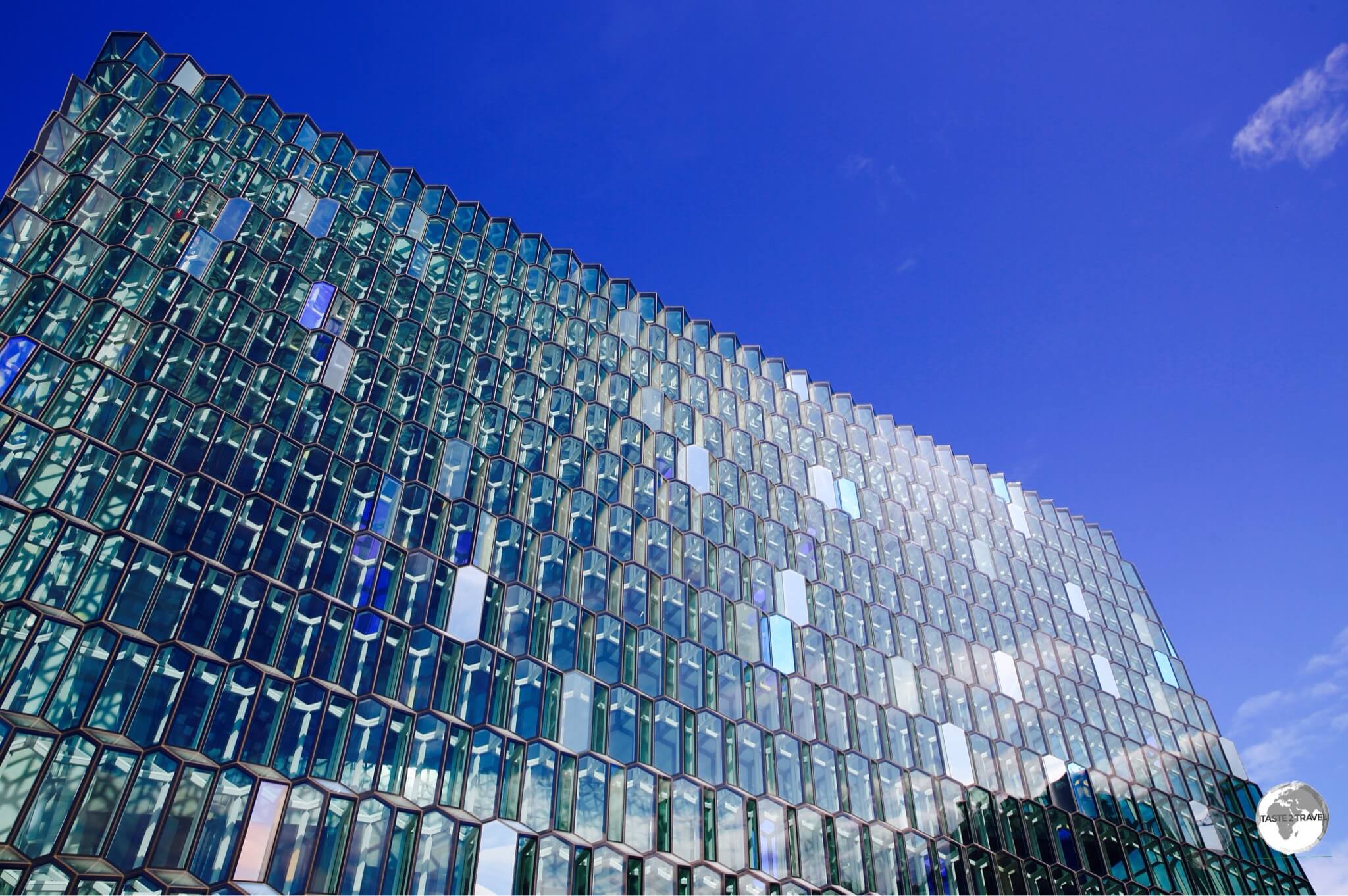 The distinctive coloured glass facade of the Harpa concert hall in Reykjavik is inspired by the basalt landscape of Iceland.