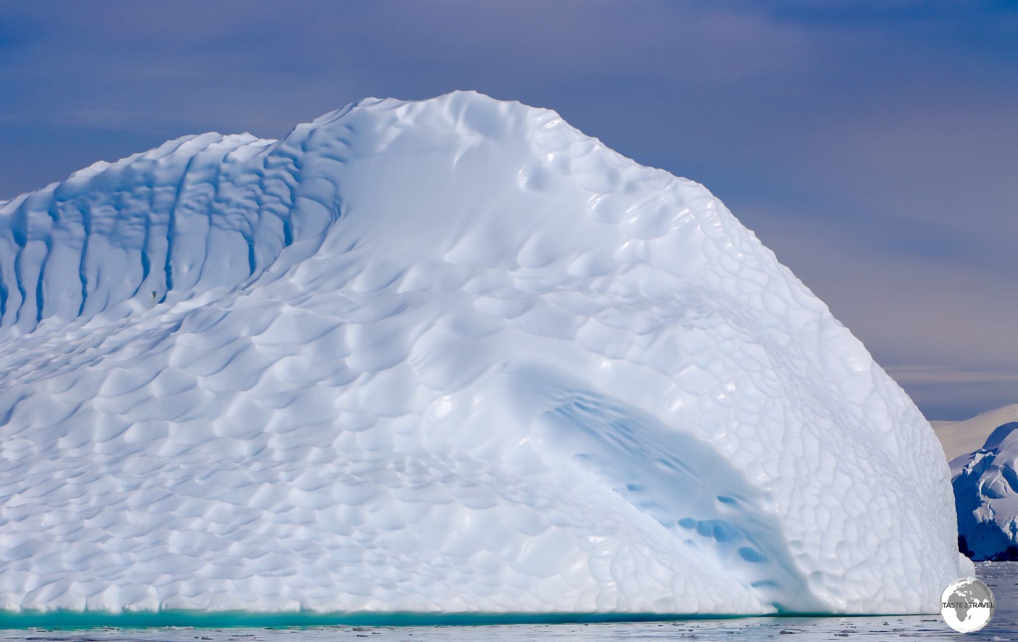 An iceberg glowing in the morning sun in the Graham passage. The dimpled effect is caused by water action when the iceberg is below the waterline.