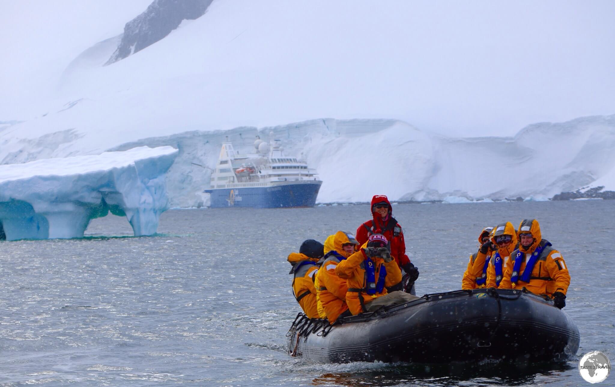 Zodiac cruising around Damoy point with the Ocean Diamond moored in the Neumayer Channel.