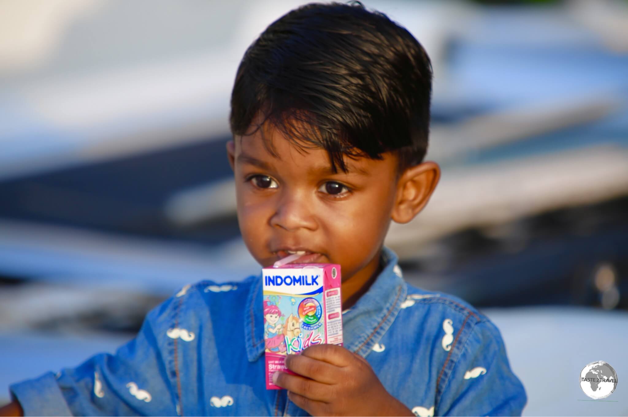 A young boy, enjoying his milk, on Maafushi Island.