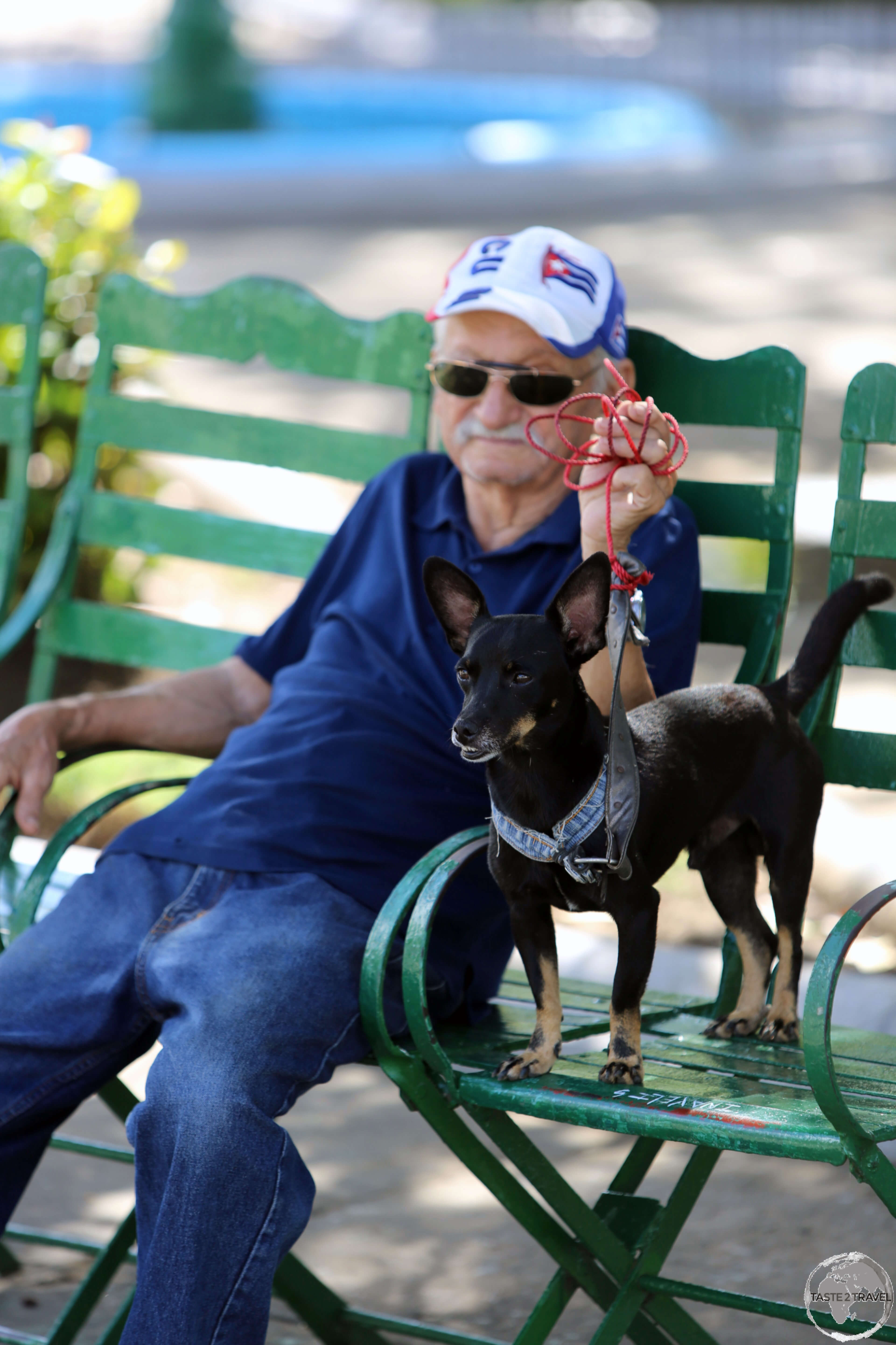 A proud dog owner relaxing in <i>Plaza José Martí</i> in Cienfuegos.