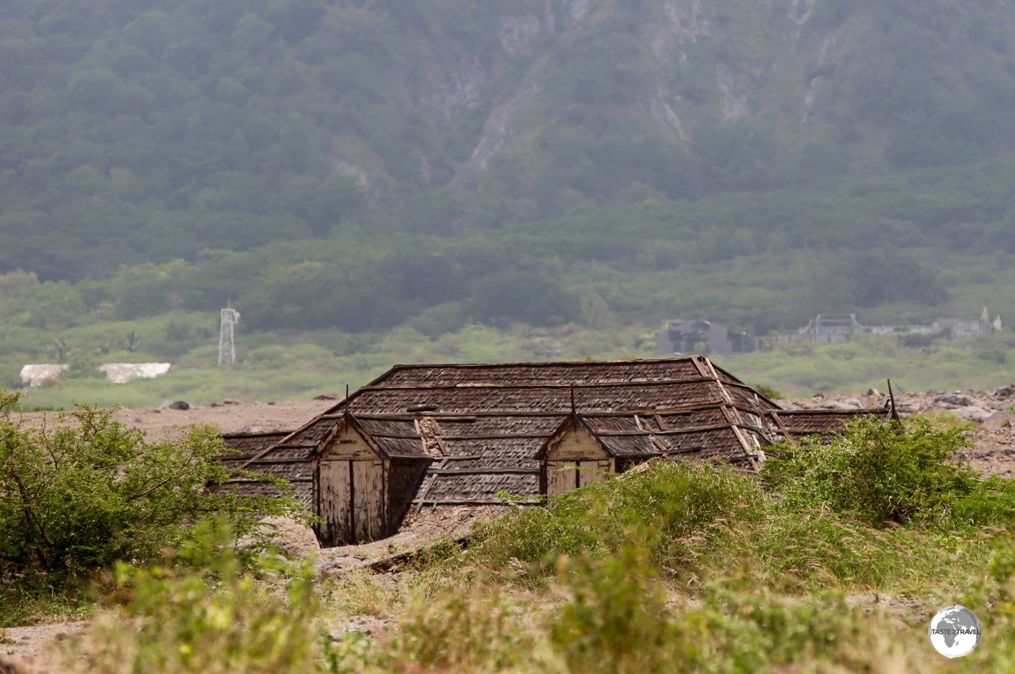 Inundated by pyroclastic flows, only the roof of this building remains visible.