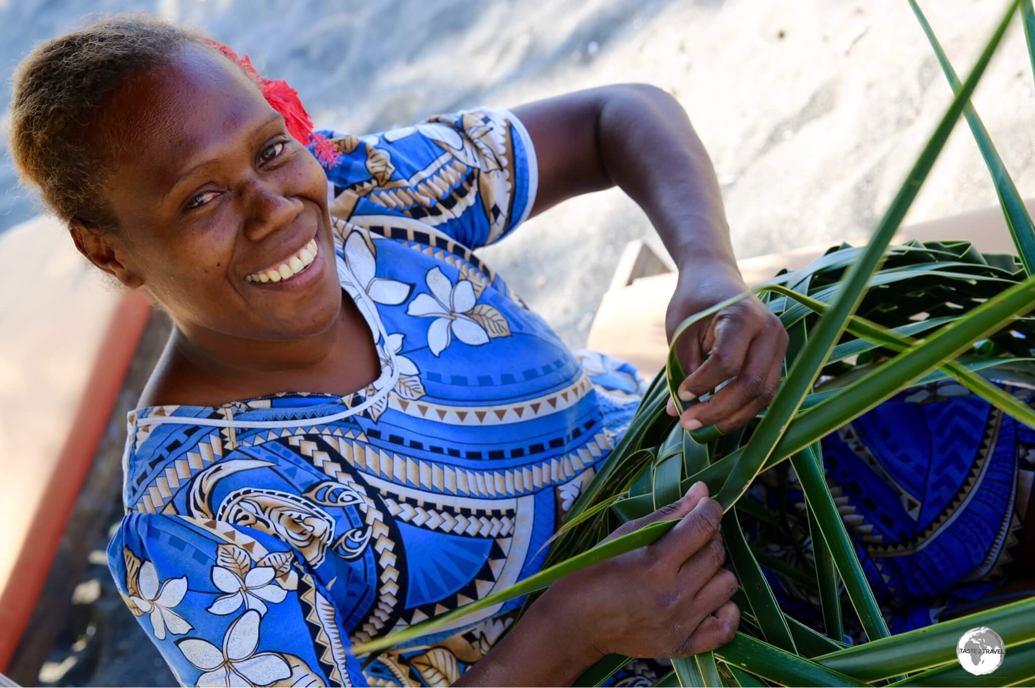 One of the friendly staff members at Friendly Beach Resort weaving a traditional basket.