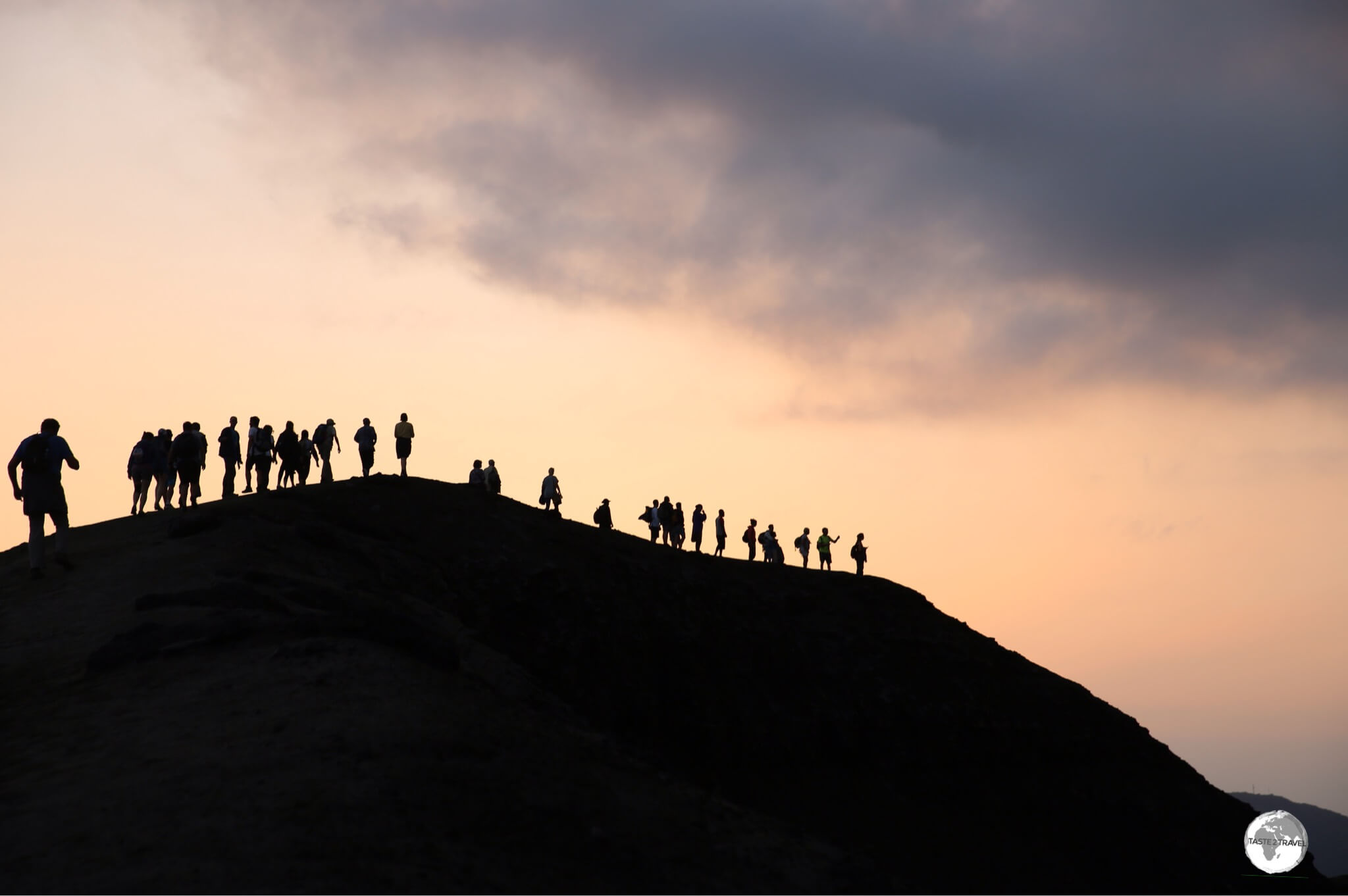 Walking at dusk along the edge of the crater at Mount Yasur.