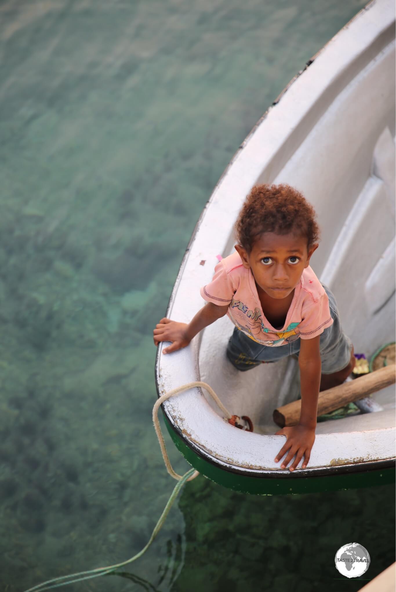 A young boy waiting on a boat in Port Vila harbour.