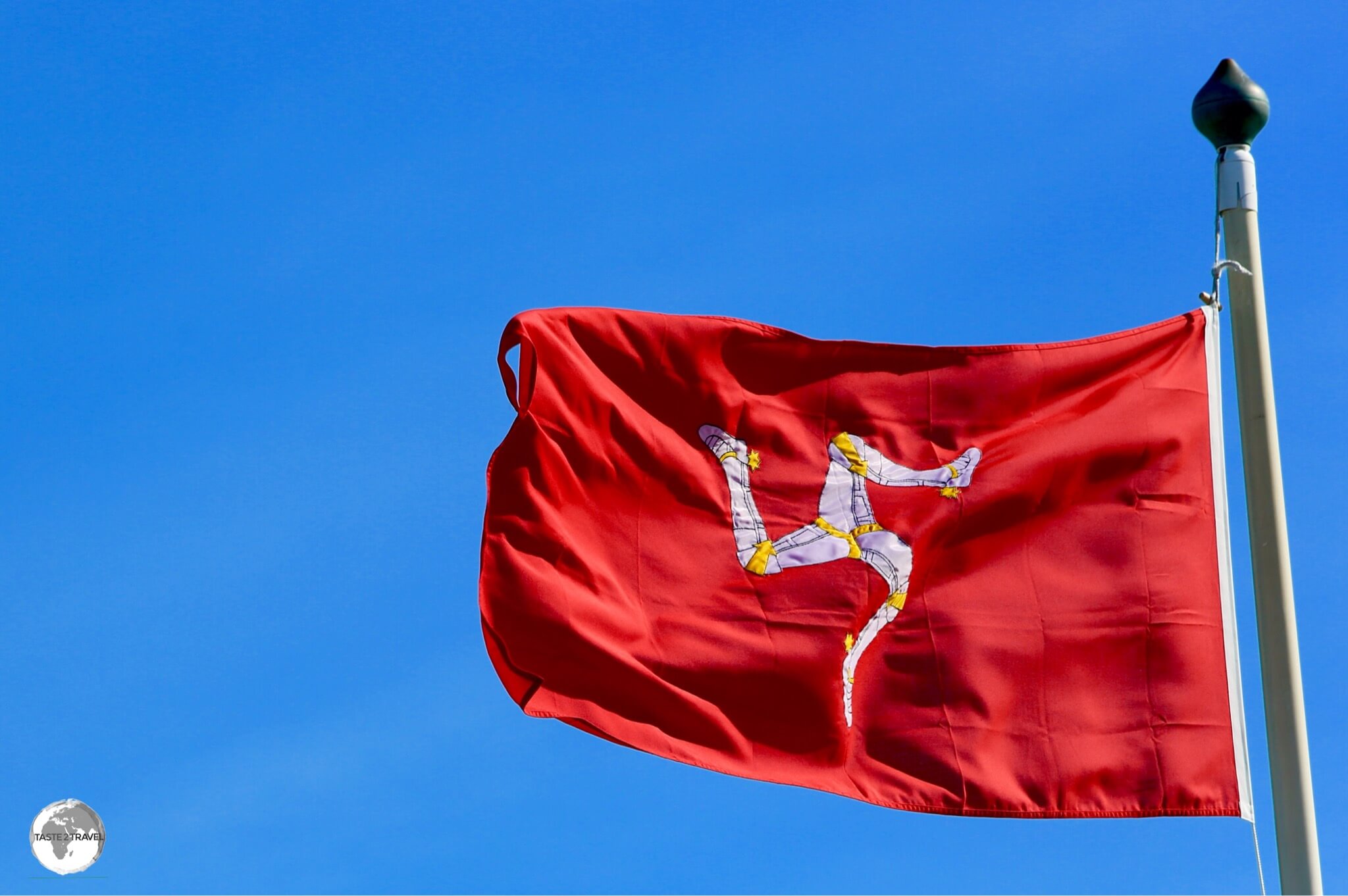 The Isle of Man flag fluttering in the breeze on the promenade in Douglas.