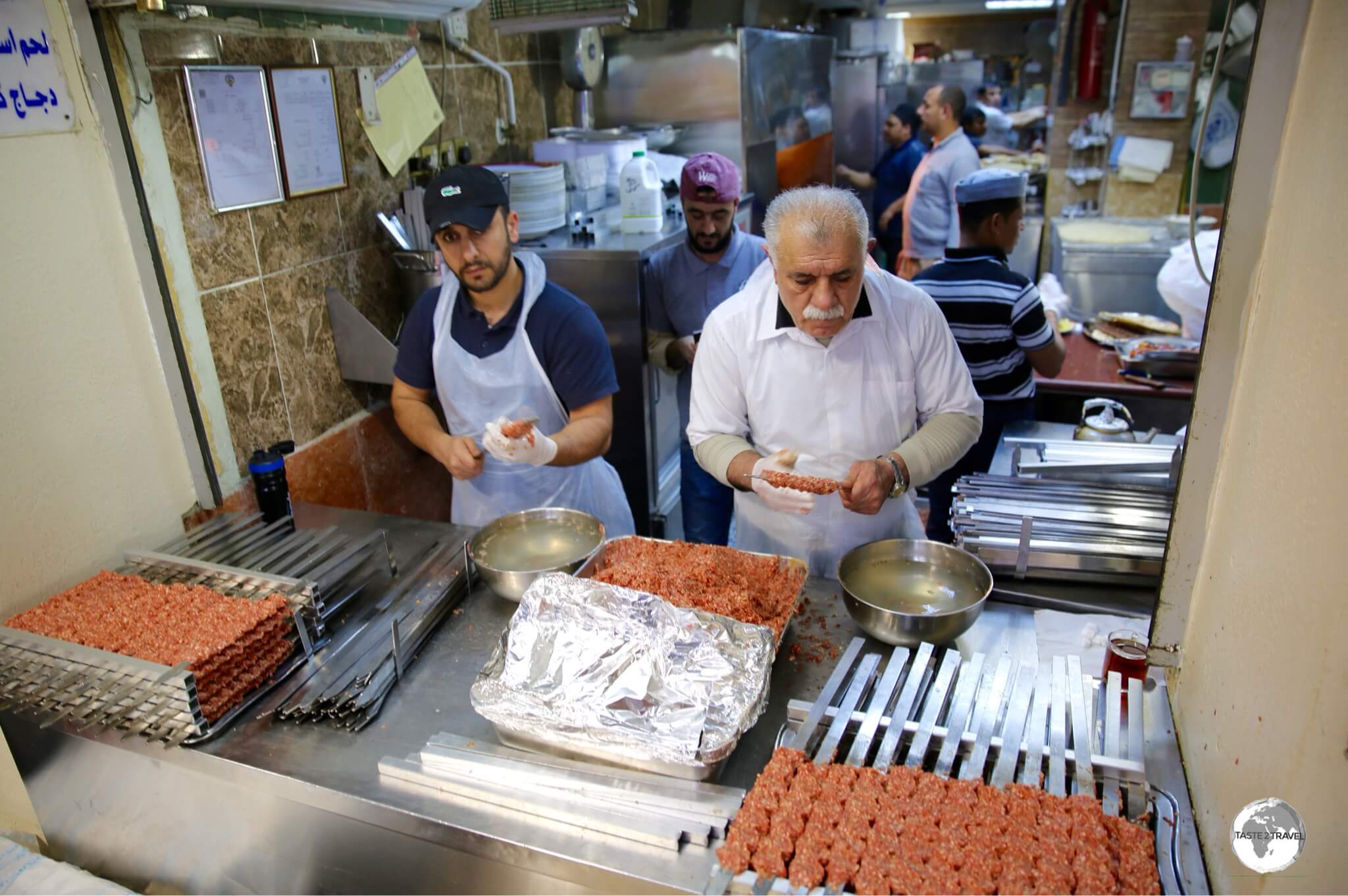 Two chefs preparing Kofte shish kebabs at Souk Al-Mubarakiya.