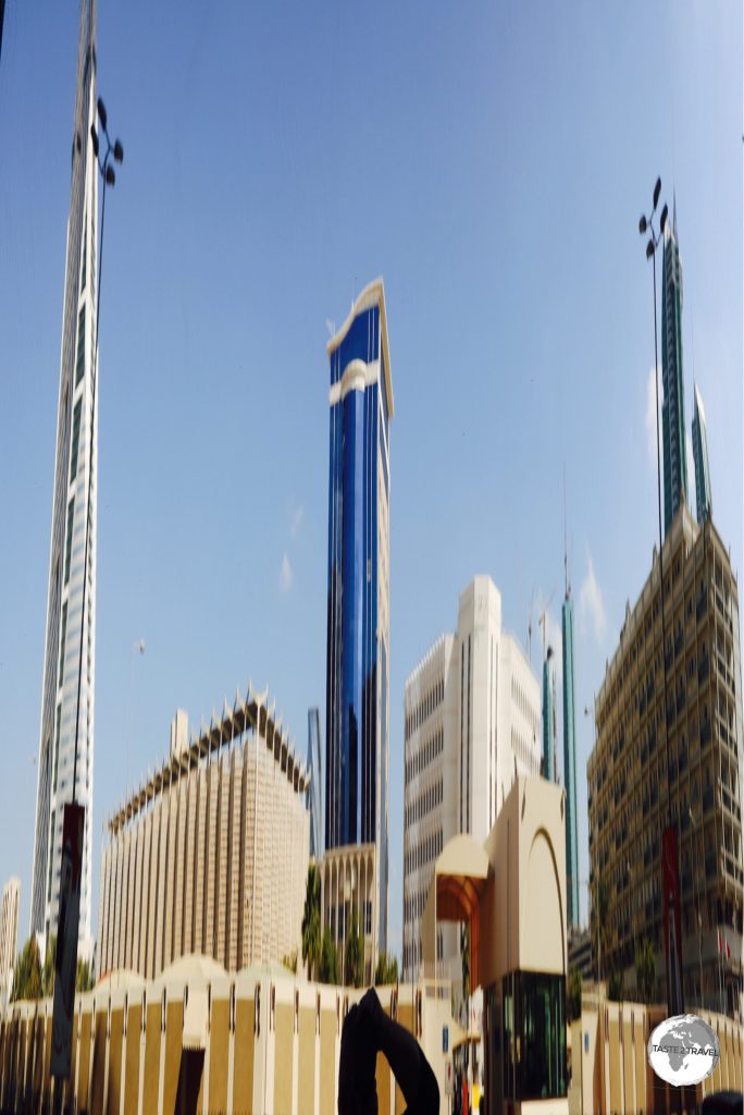 The skyline of the capital, Manama, reflected through the window of a modern office building.