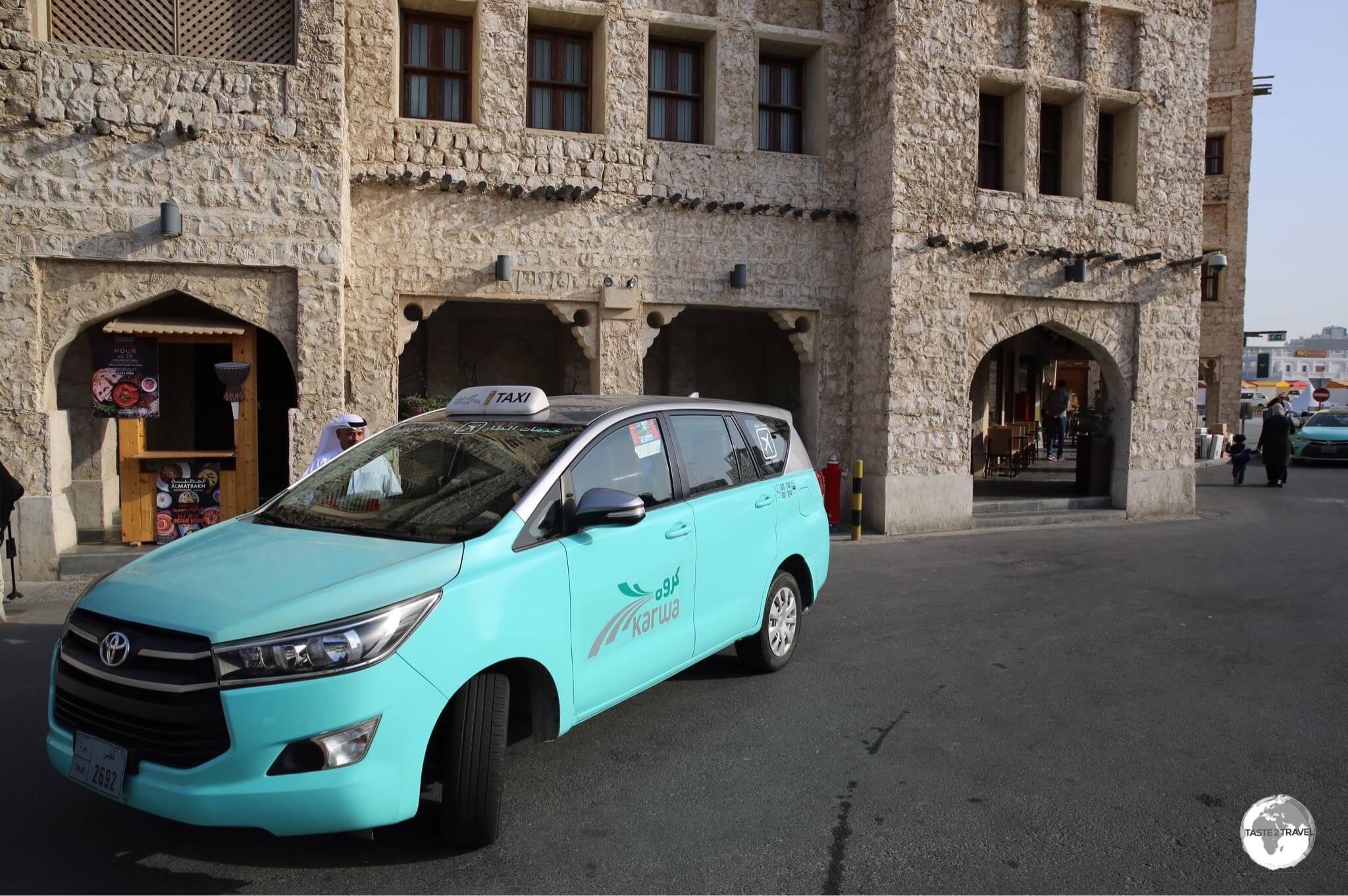 A turquoise-coloured Doha Taxi outside Souk Waqif.