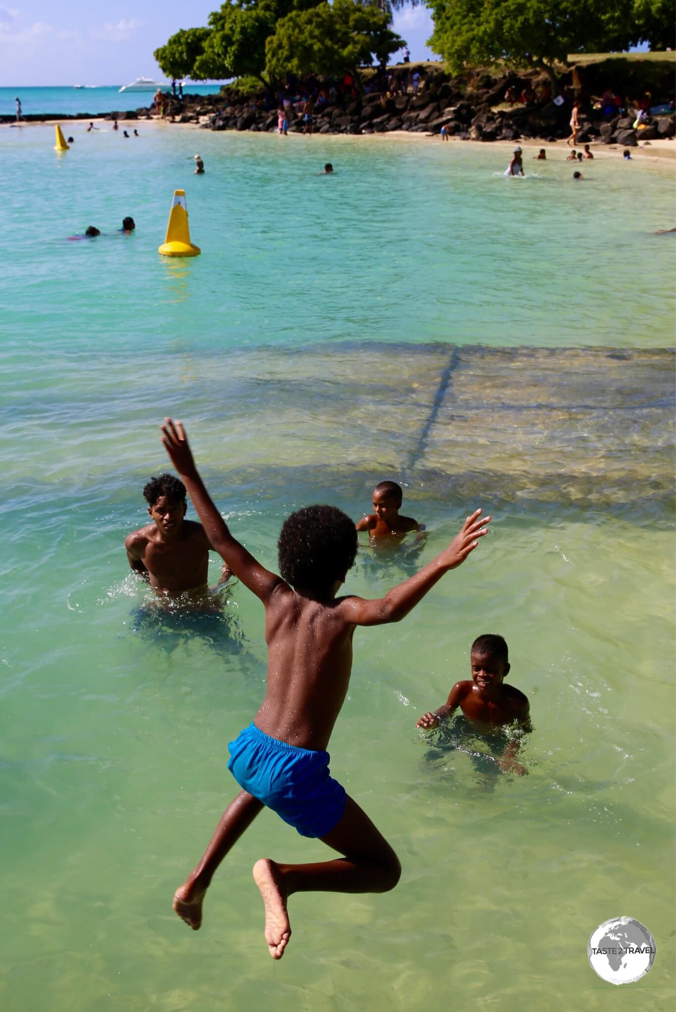 Young Mauritian boys enjoying the beach at Grand Baie. 