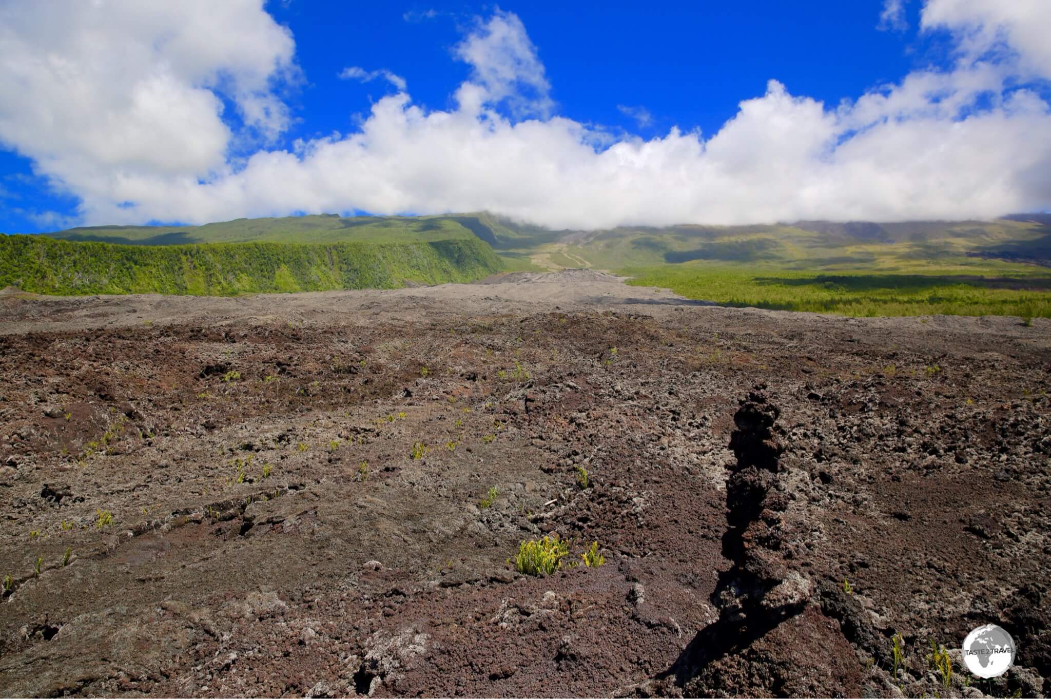 One of many huge lava fields which flow down to the south coast of Reunion from the Piton de la Fournaise, which is shrouded by cloud cover.