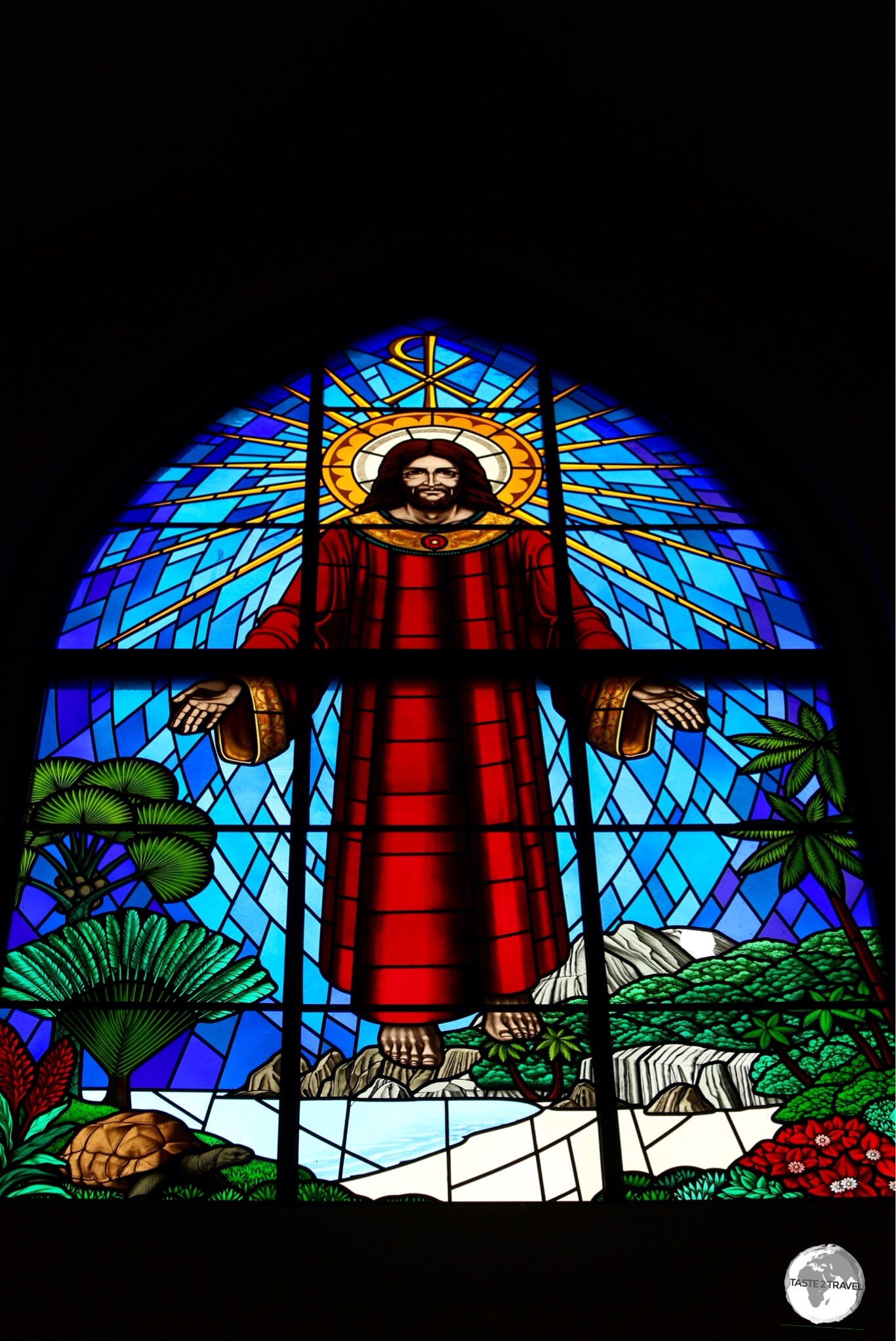 The window above the narthex of St. Paul's features Jesus floating above a typical Seychellois island with granite boulders, palm trees and an Aldabra giant tortoise. 