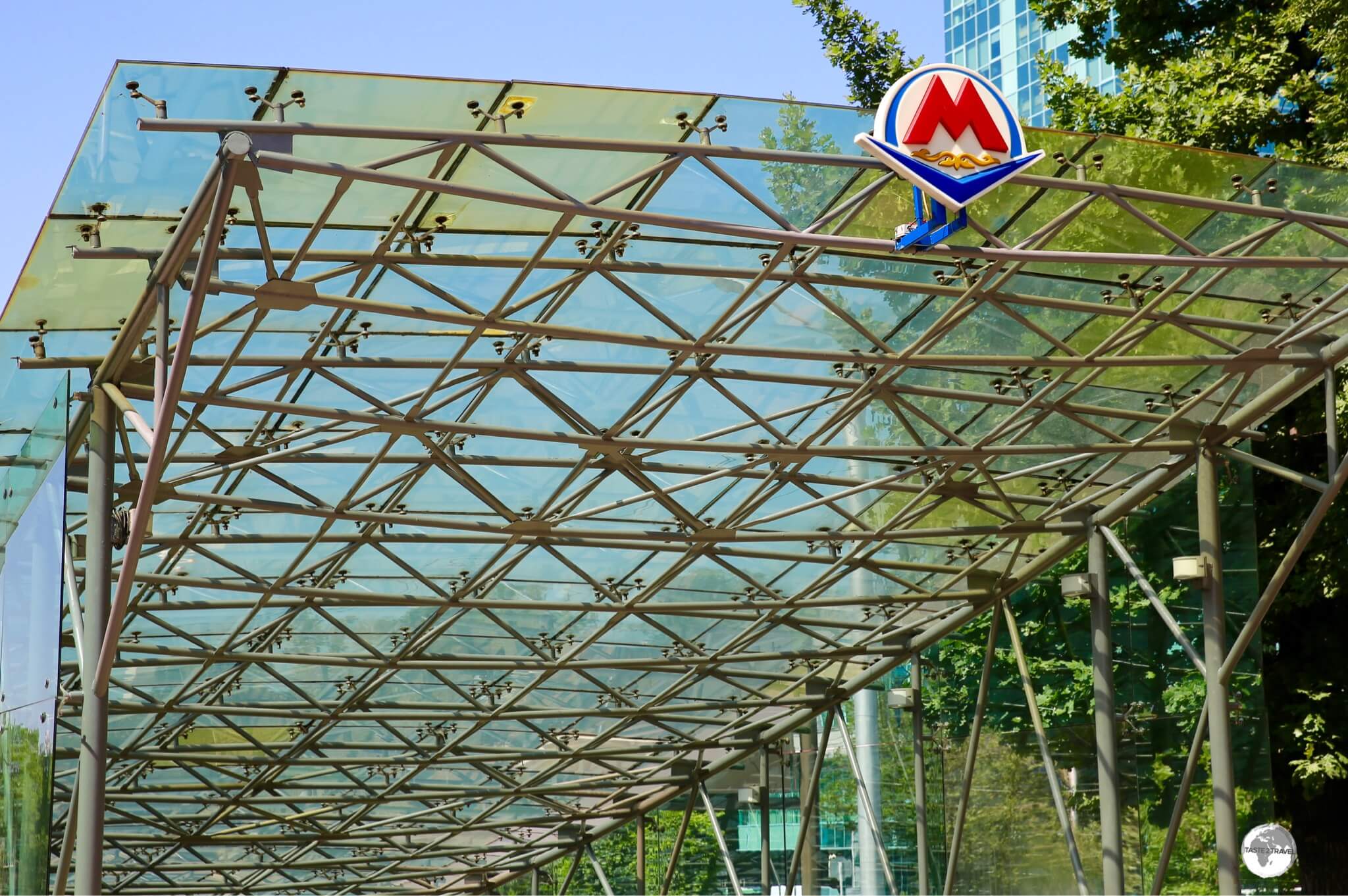 All metro entrances features the same glass canopy and the red 'M' metro logo. 