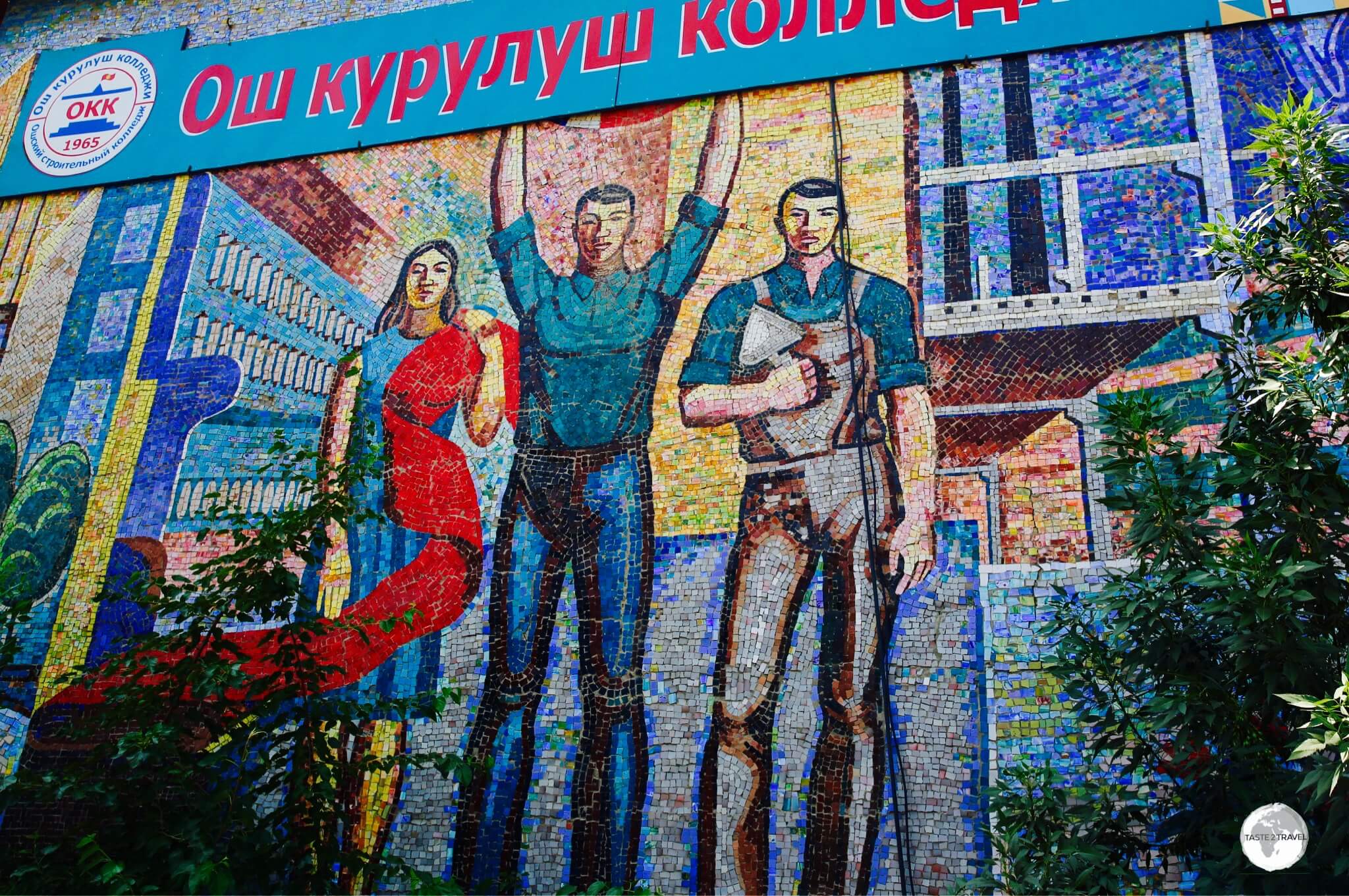 The <b><i>Fabric</i></b> mosaic is installed on the wall of a local technical college and shows three different workers, with one holding a length of red cloth, a symbol of communism.