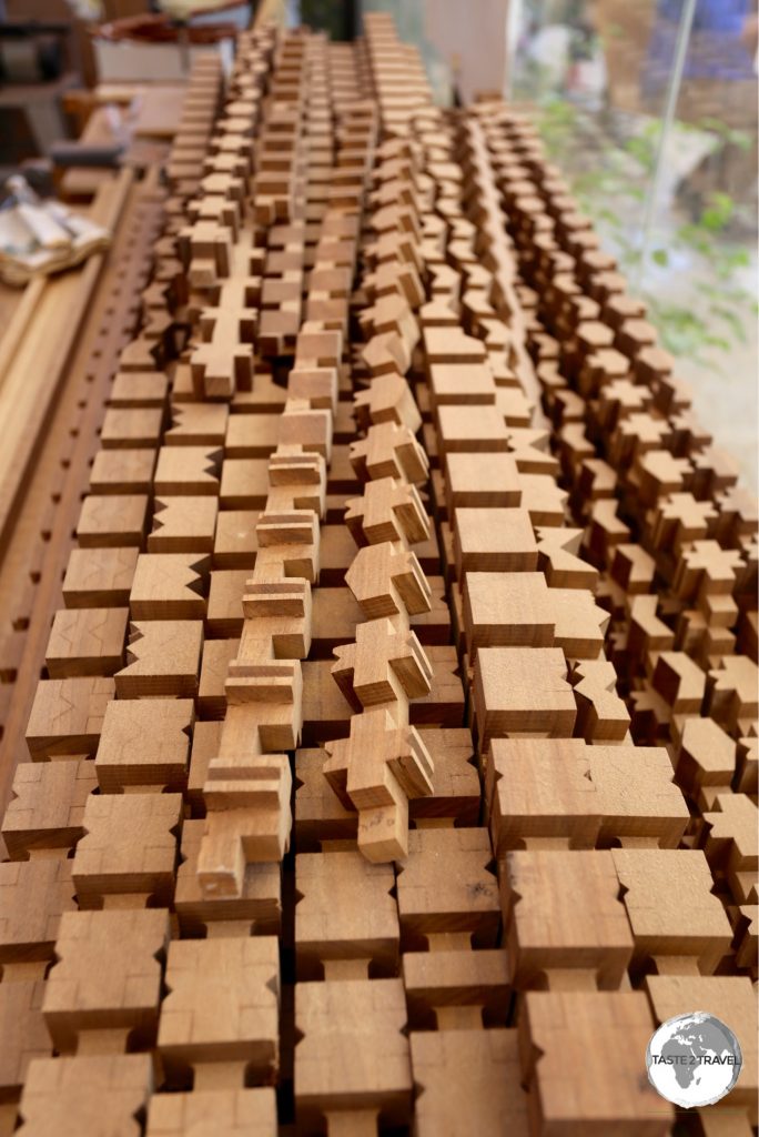 Pieces of carved mahogany, ready to be assembled into a lattice jigsaw.