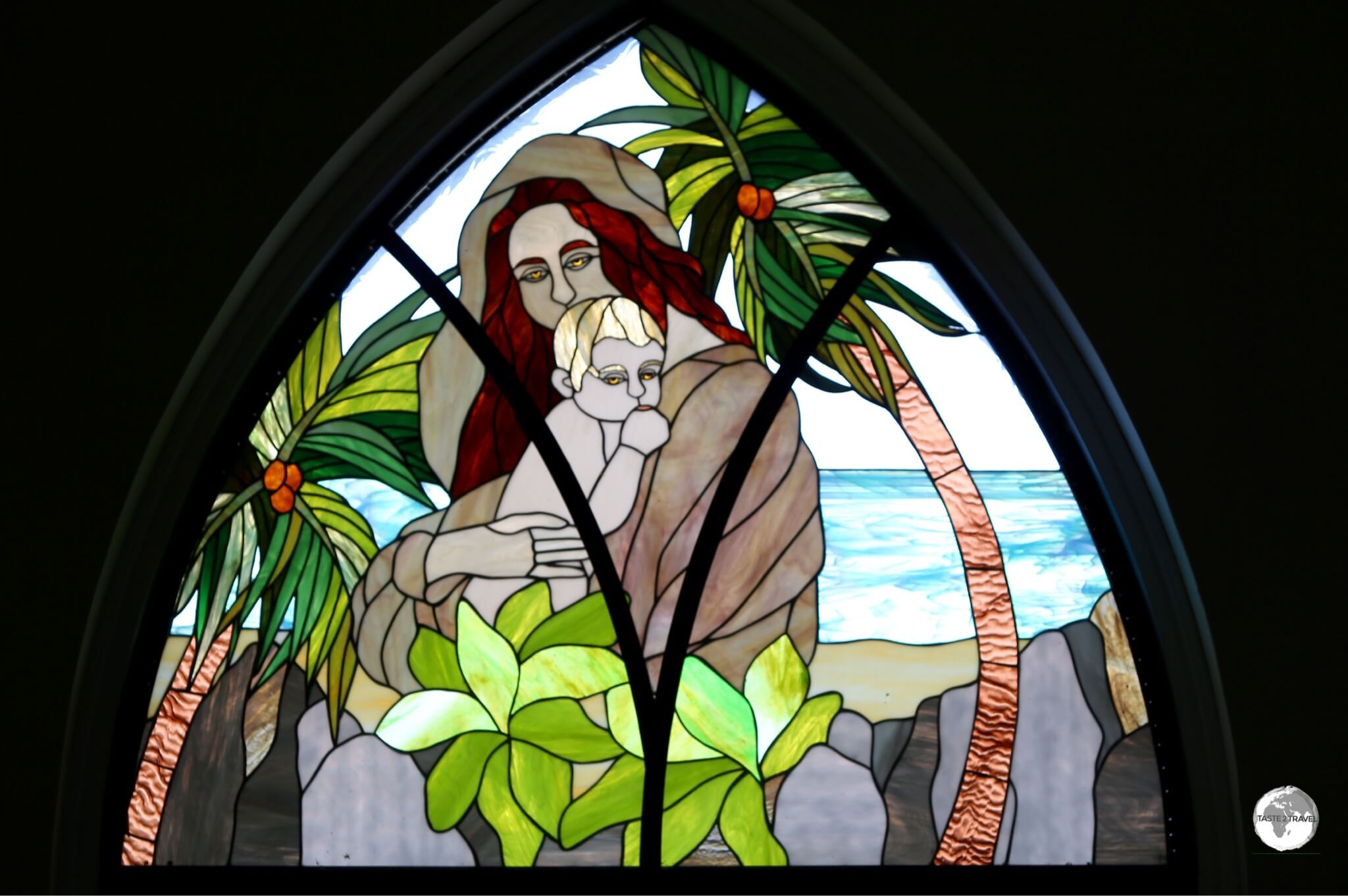 Another colourful window depicts 'Madonna and Child' in a typical Seychellois setting, on a white-sand beach surround by palm trees and granite boulders.