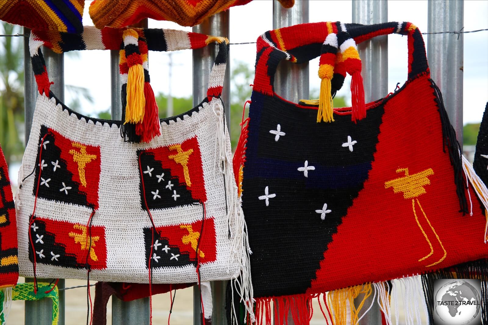 The flag of PNG is often featured on local crafts, such as these handwoven <i> bilums </i> on sale in Madang market. 