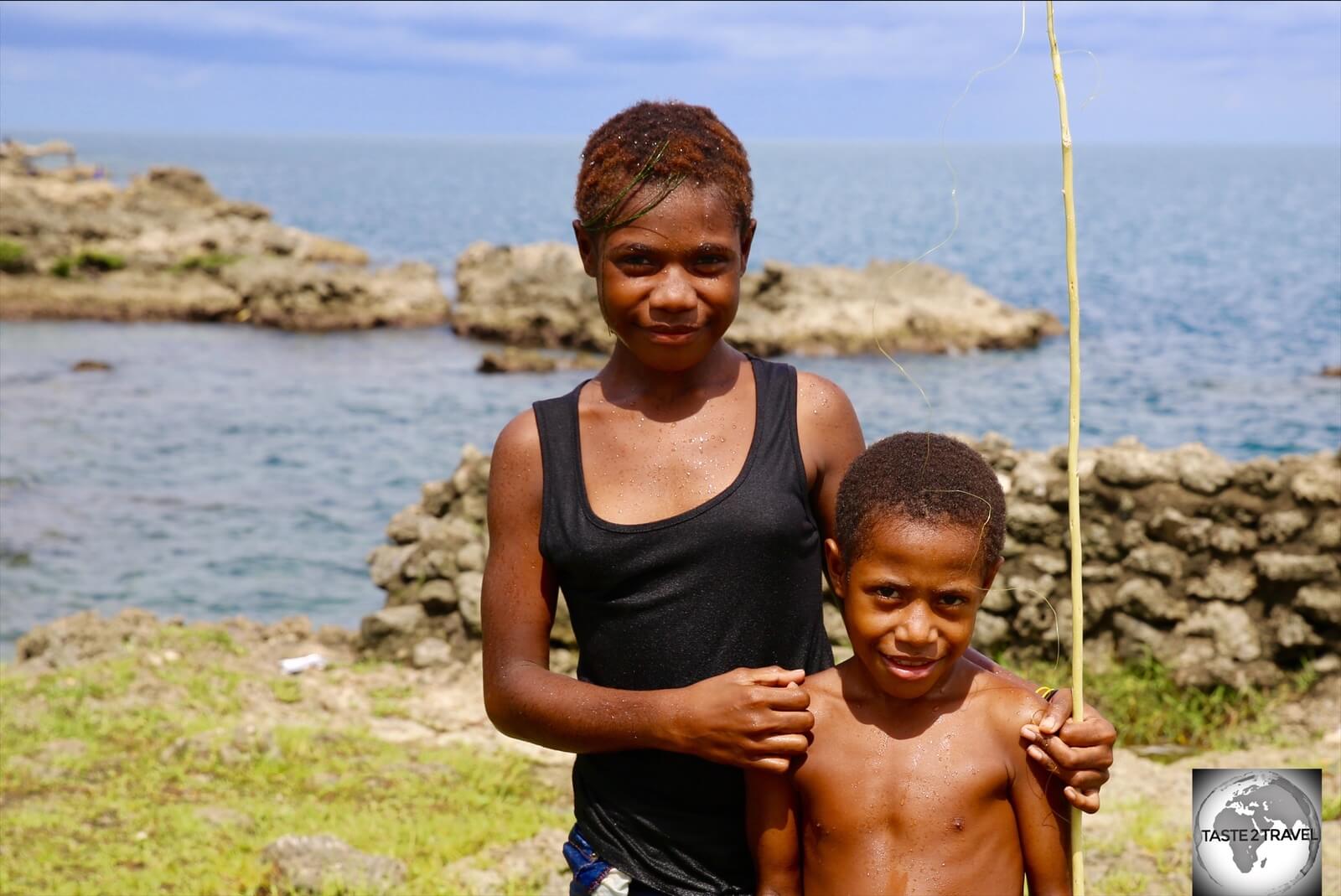 A sister, with her brother, at Machine Gun beach in Madang.