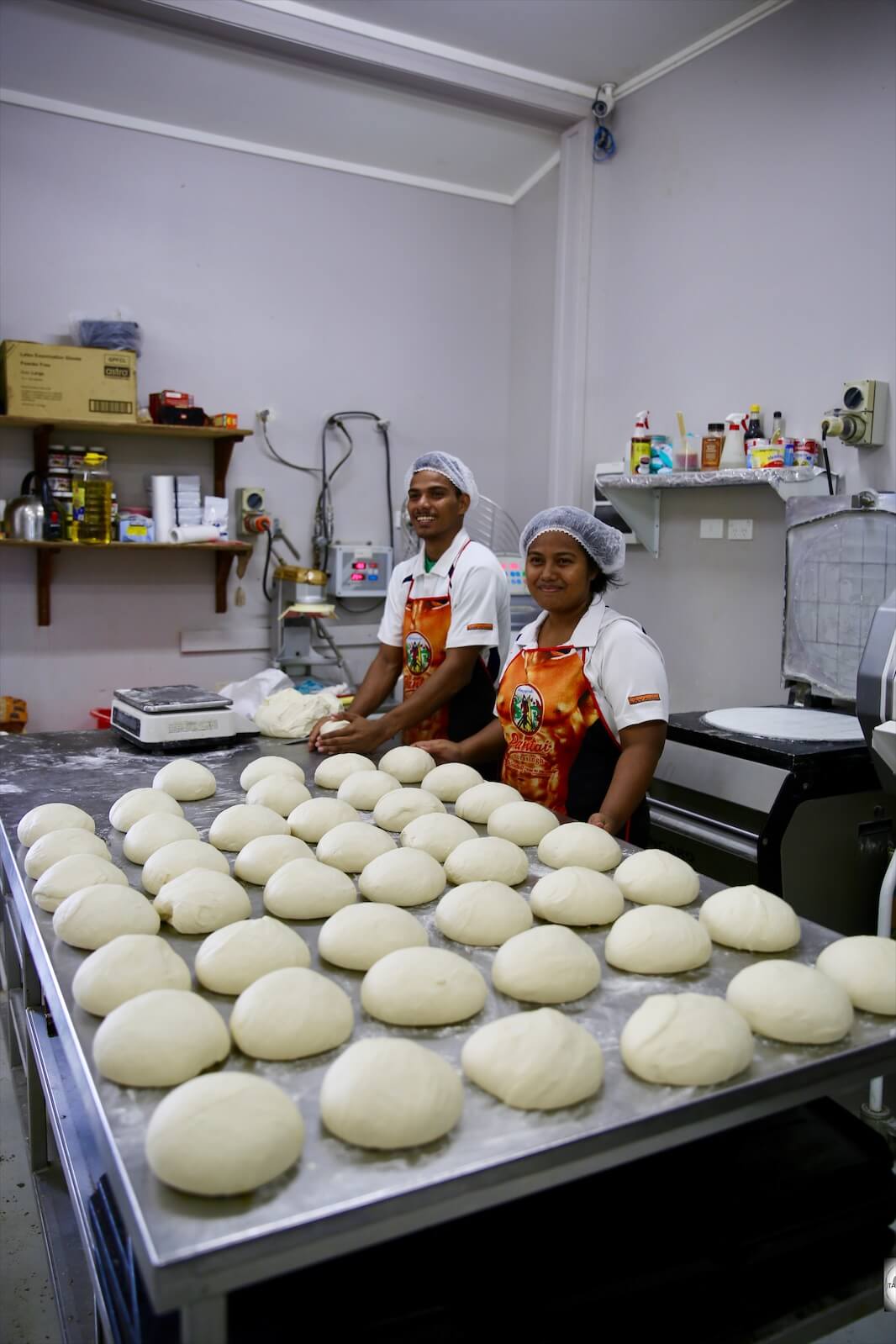 Staff at 'Buns in the Sun' preparing fresh bread rolls.