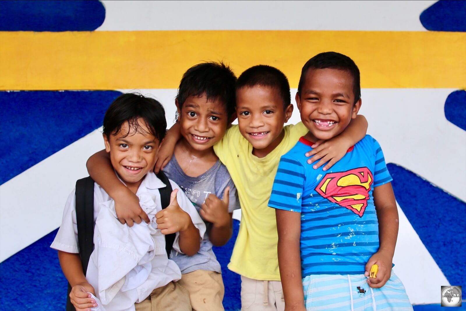 Boys posing in front of a giant flag of Nauru which adorns the wall of the Civic centre.