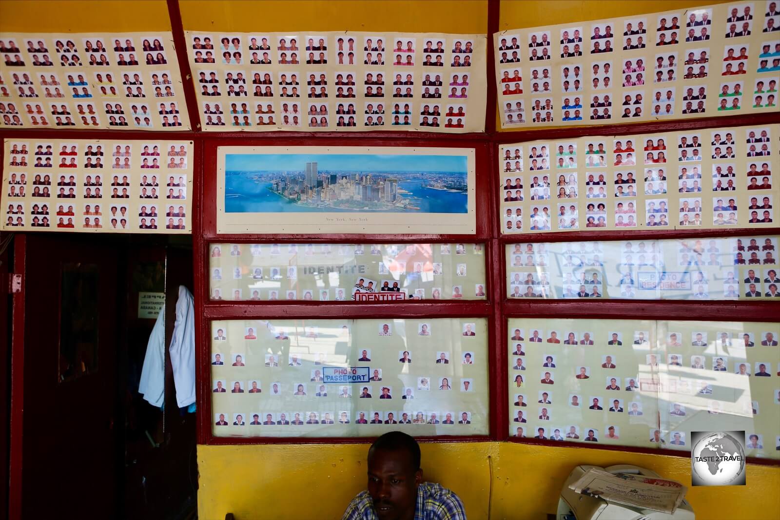 Passport photos line the wall of a photo studio in downtown PAP. 