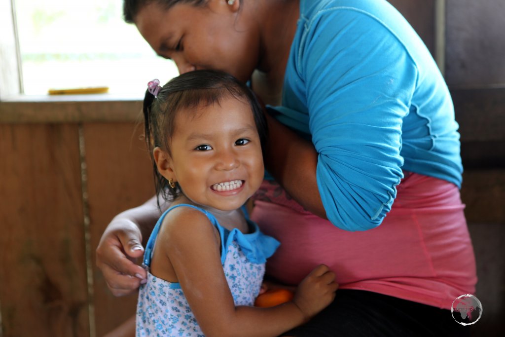 A young indigenous girl and her mother on the Peruvian side of the Amazon river in the Tres Fronteras region.