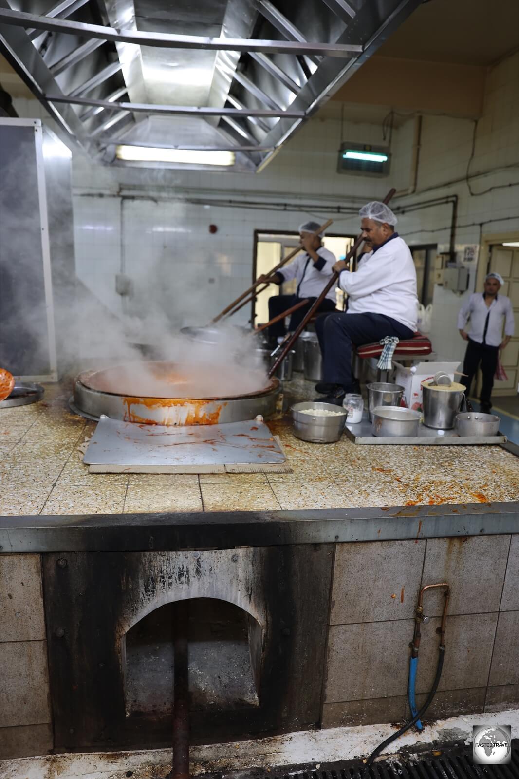 The production technique for Halwa involves cooking ingredients inside large copper vats which are heated by four gas burners which are placed under a raised platform.