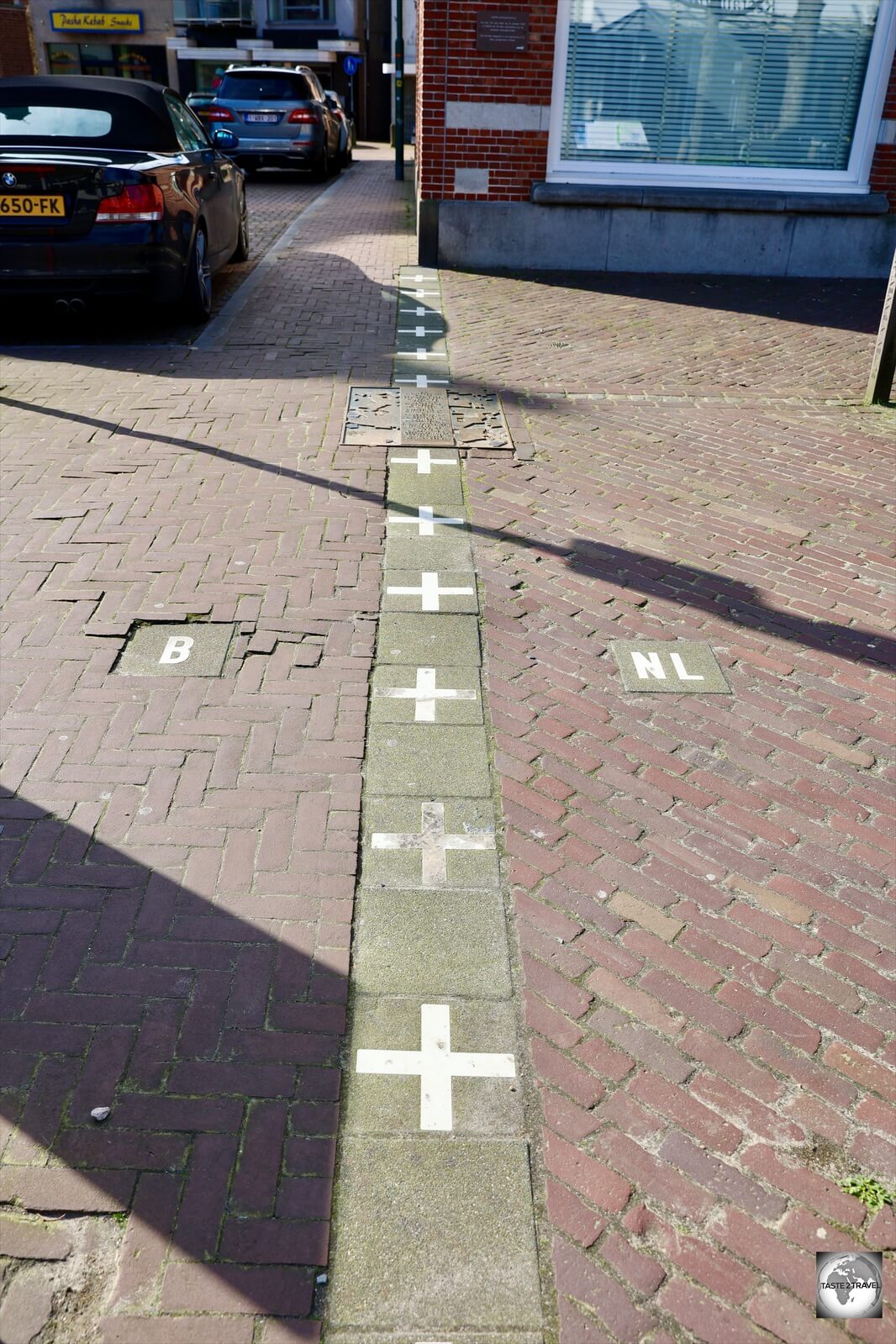 In Baarle, white crosses are used to indicate borderlines on footpaths along with a 'B' or 'NL'.