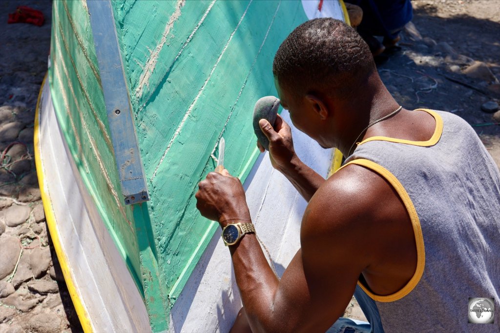 Local fisherman 'corking' his wooden fishing boat in Porto Mosquito, Santiago Island..