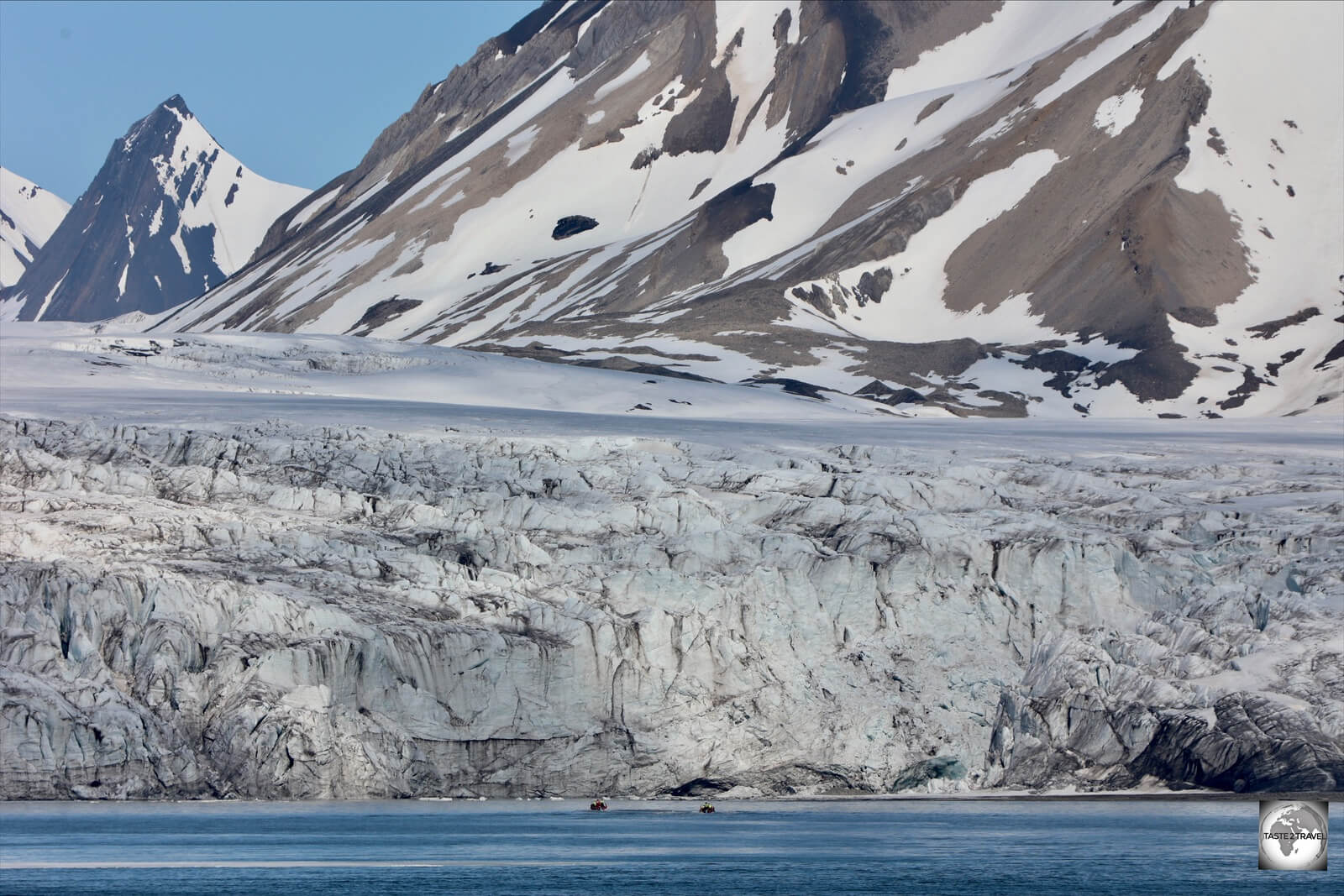 Two zodiac boats are dwarfed by the front of the Esmark glacier, which is 15 km wide.