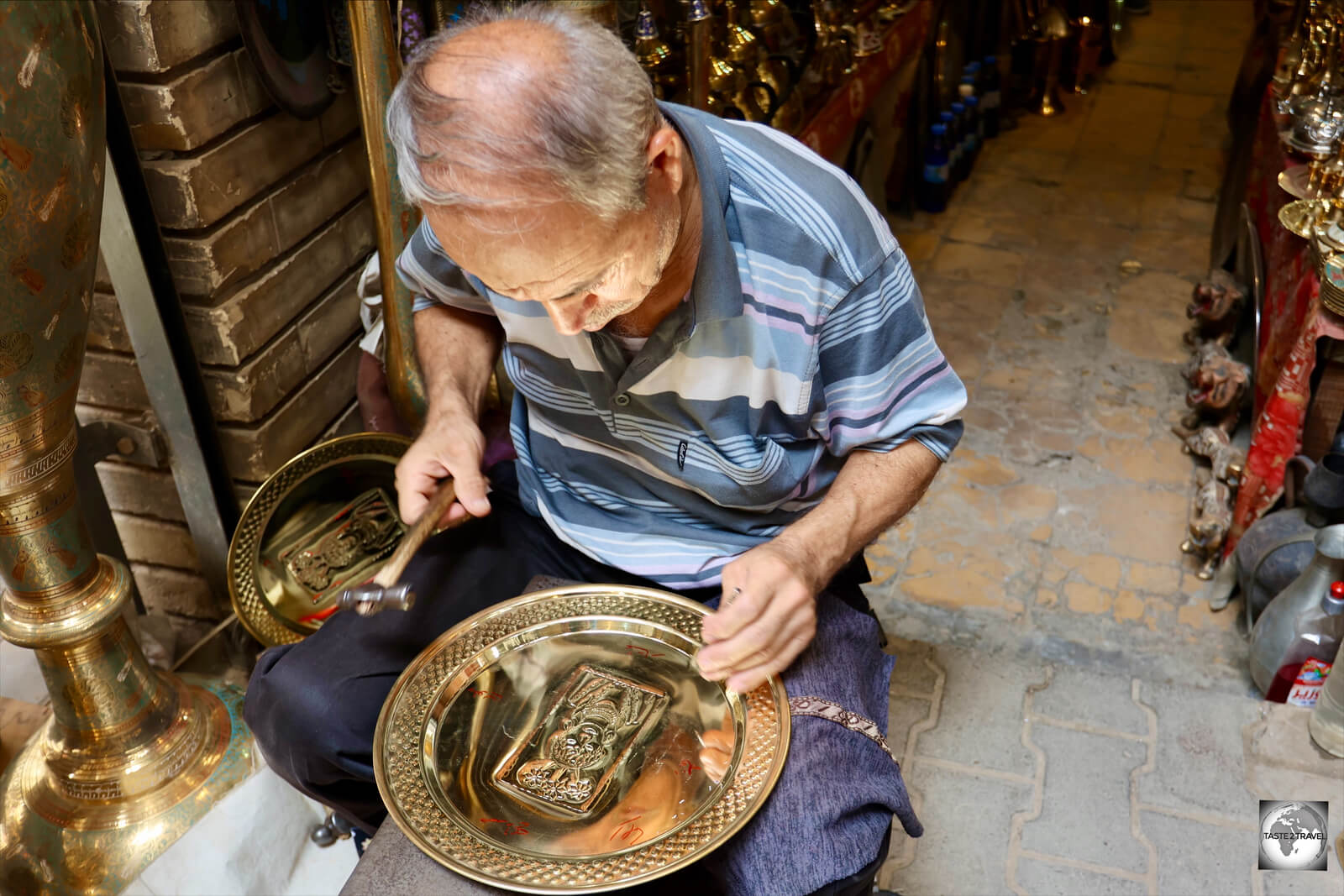 An artisan, engraving a copper platter at the Al-Safafeer copper market in Baghdad.