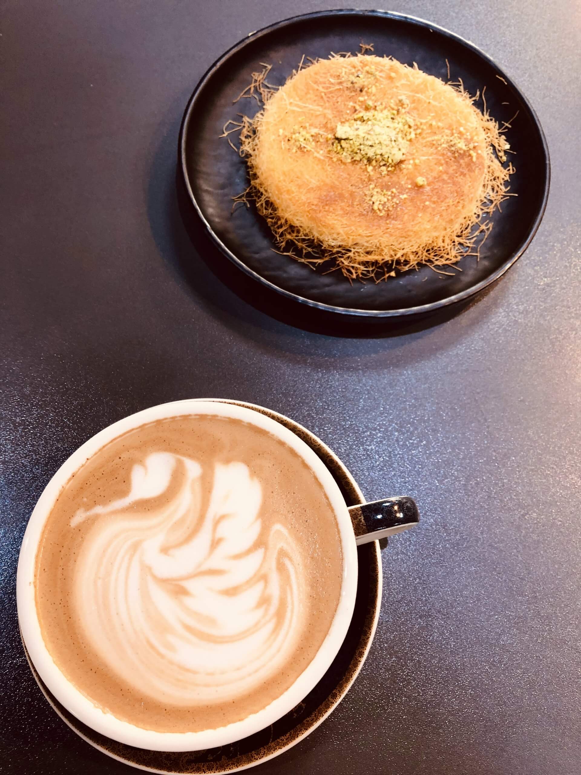 A Sydney-style coffee and an Iraqi classic halwa dessert at Caramel cafe in Karbala.