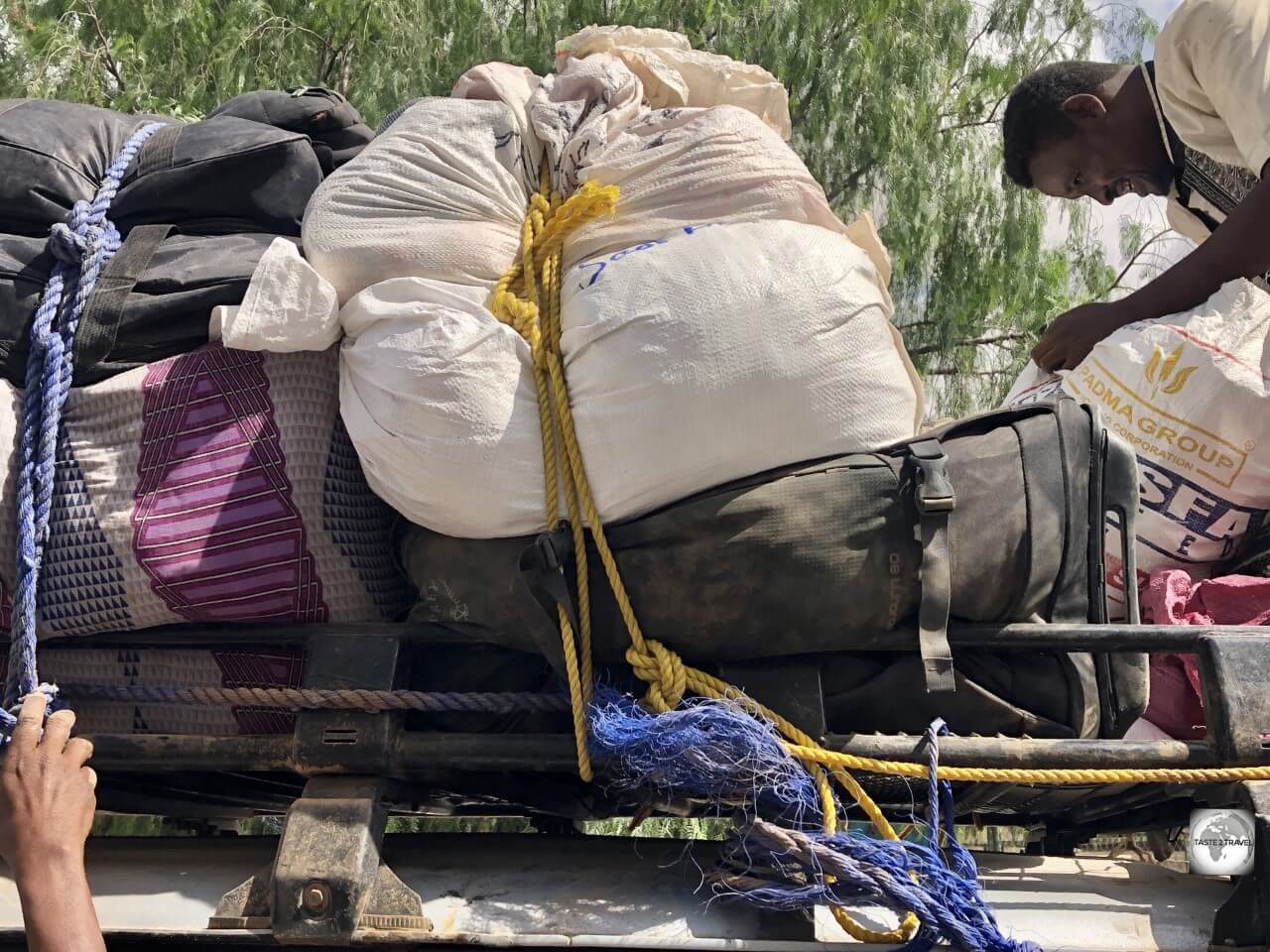 My beautiful Osprey travel bag, covered in desert dust and crushed under a heavy white sack. 