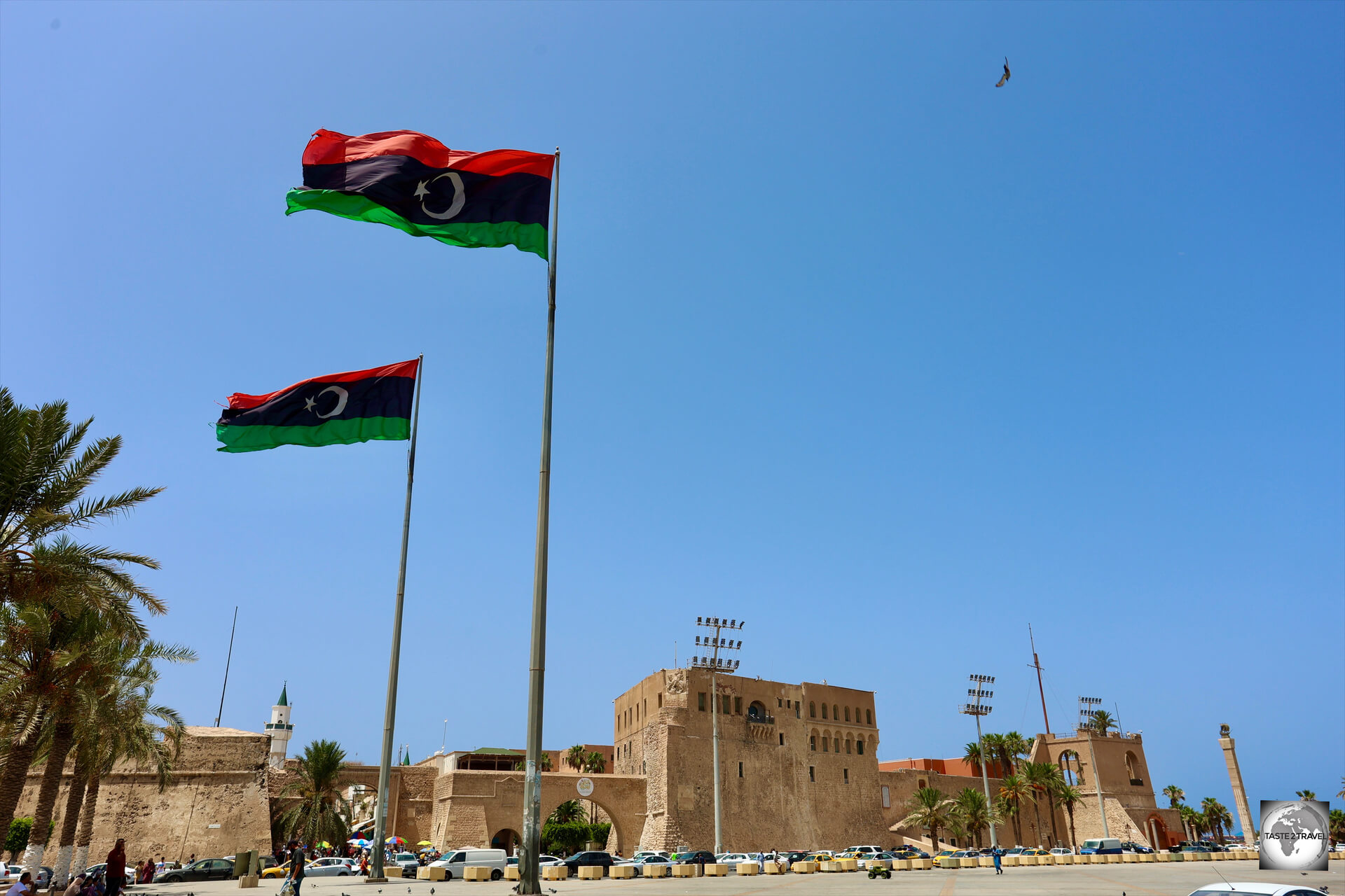 Libyan flags, flying over Martyrs' Square in Tripoli, with the walls of the medina and the Red Castle visible in the background. 