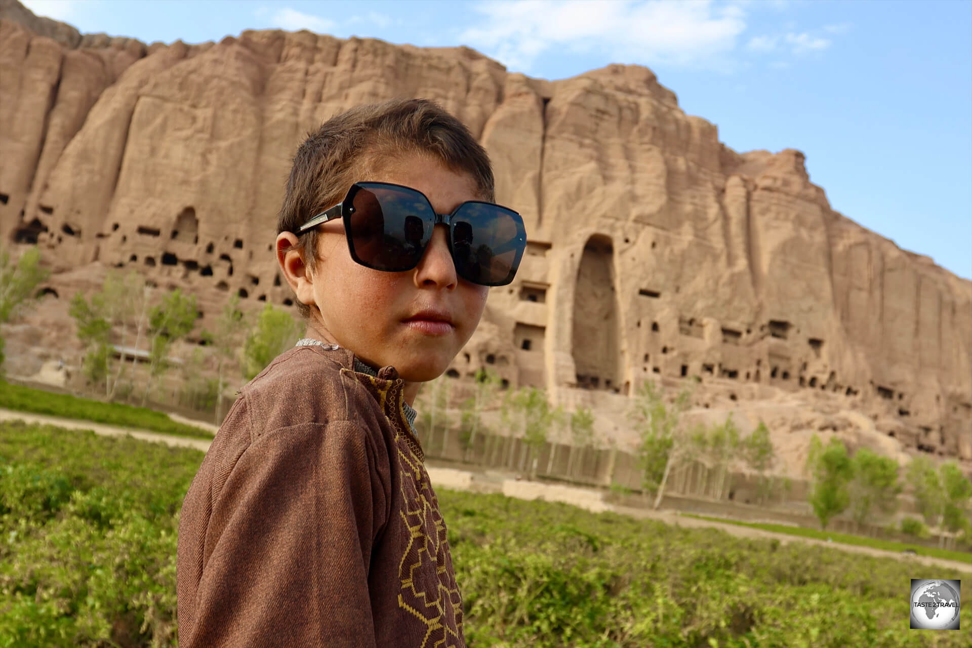 A young Afghan hipster, in front of the Eastern Buddha niche. 