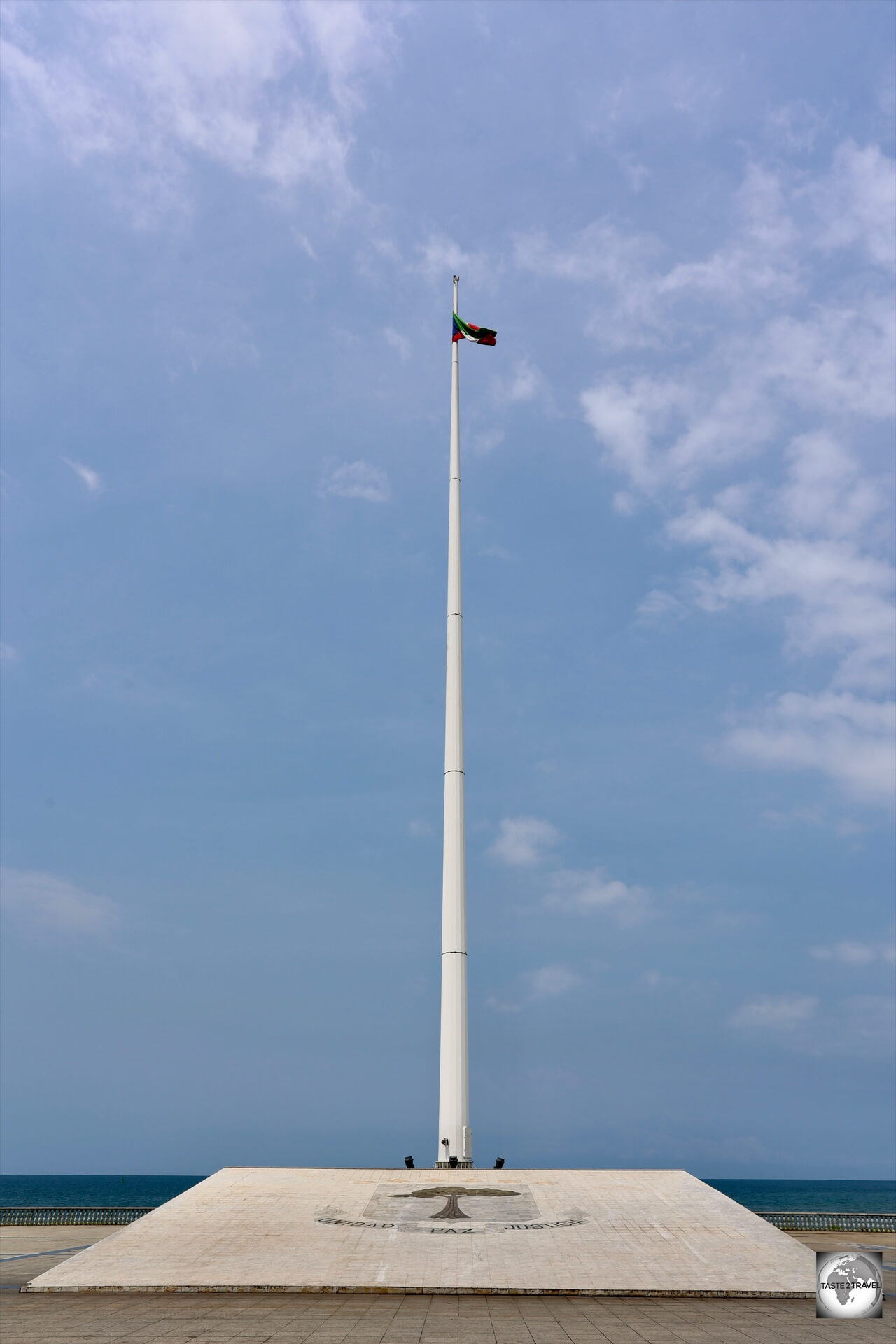 A tiny, barely visible, Equatorial Guinea flag, flying upon the tallest flagpole in Malabo at Plaza of Equatorial Guinea.