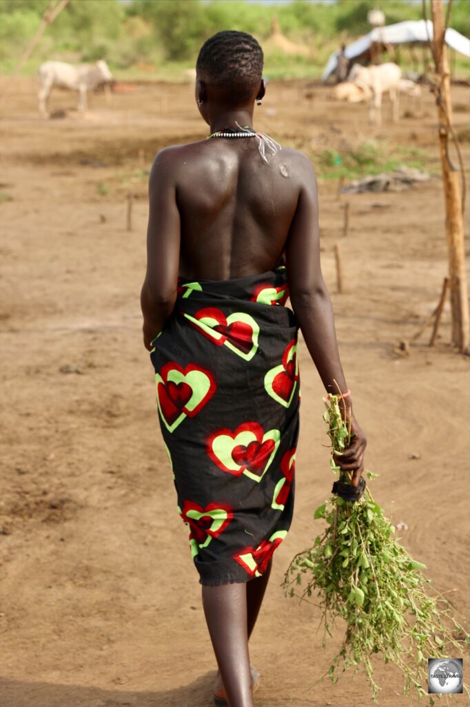 A Mundari girl, sweeping the camp grounds.