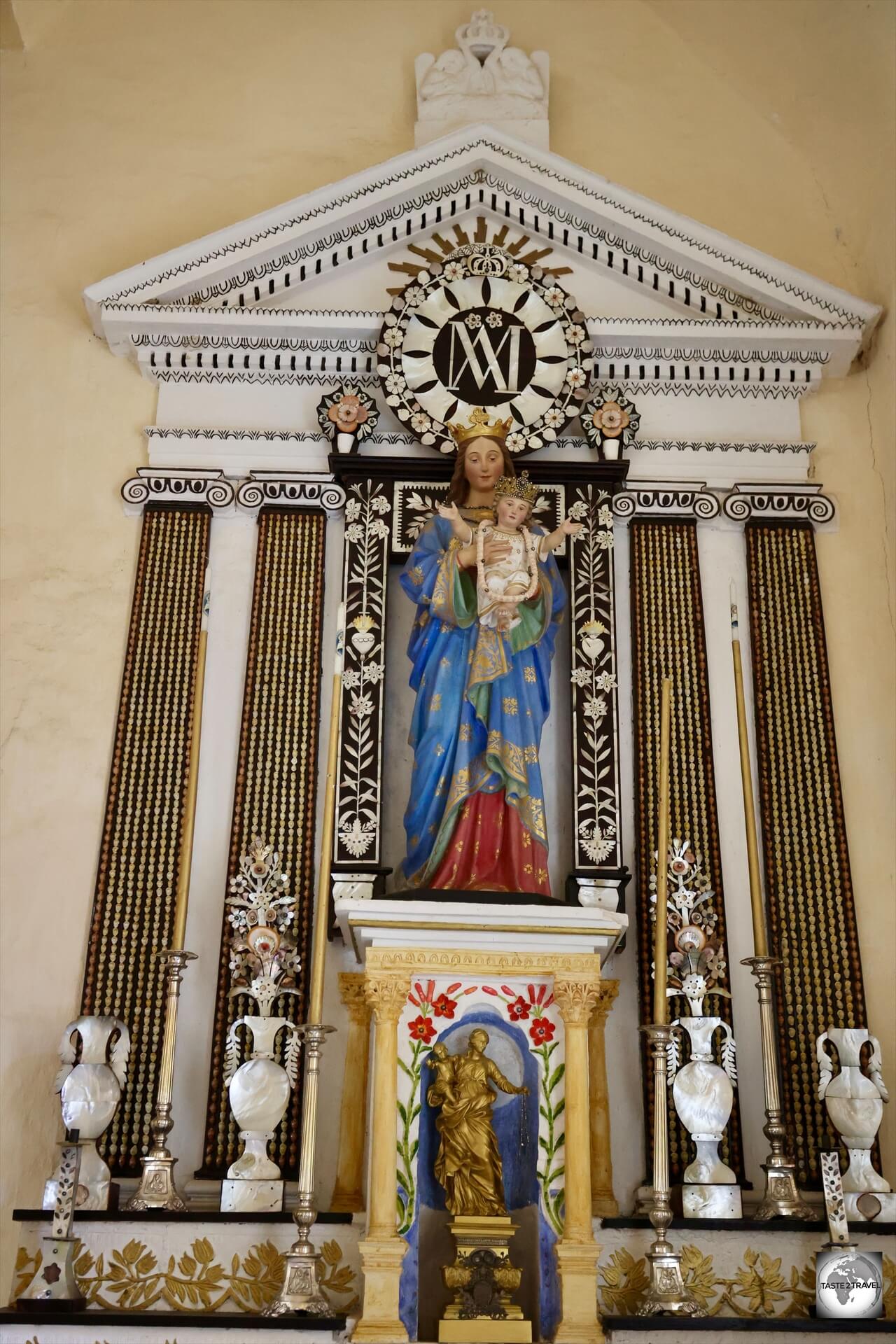 A statue of the Virgin Mary at St. Michael's Cathedral, surrounded by mother-of-pearl, shells and black pearls.