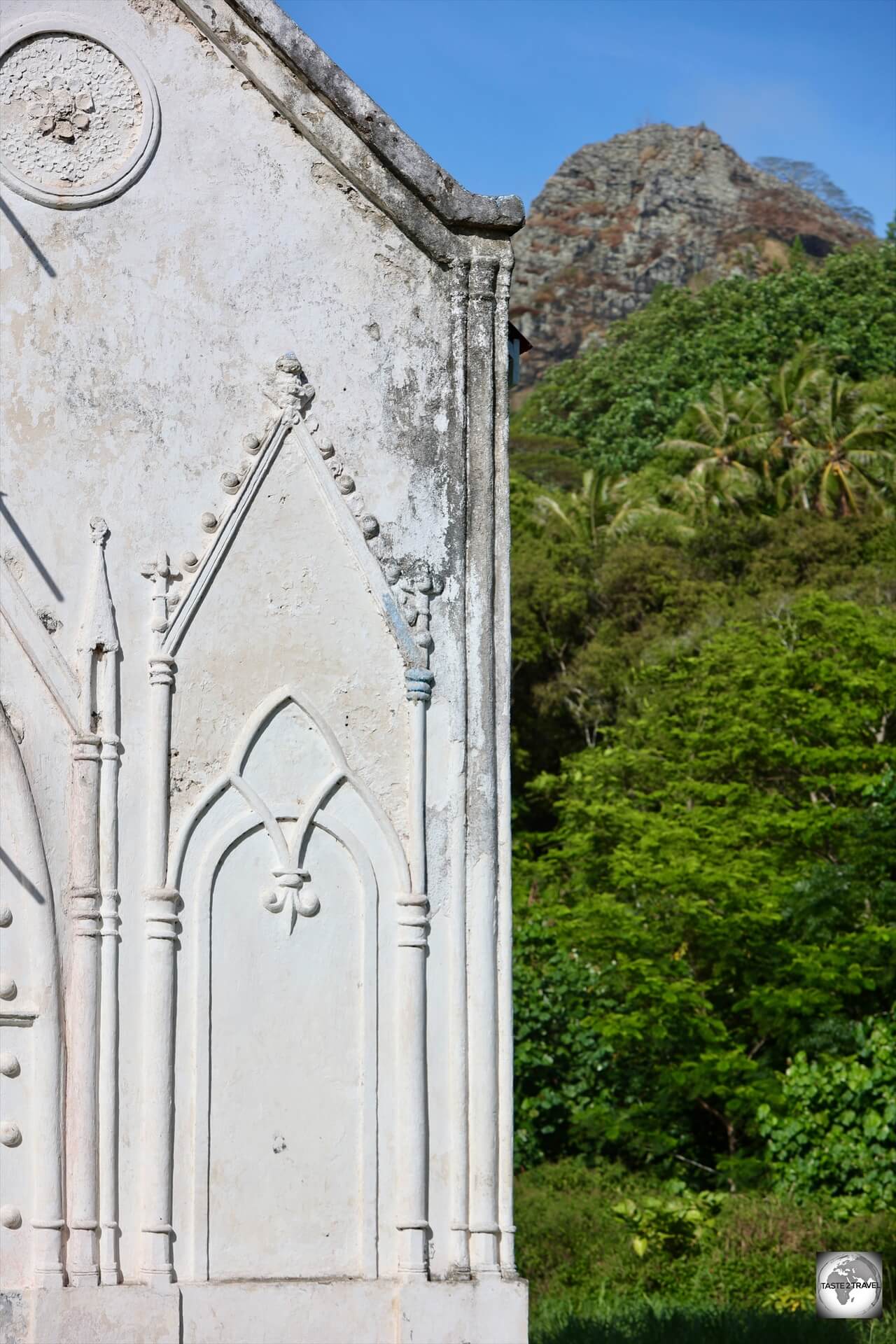 The white washed walls of the church contrast against the lush green scenery of Taravai Island.