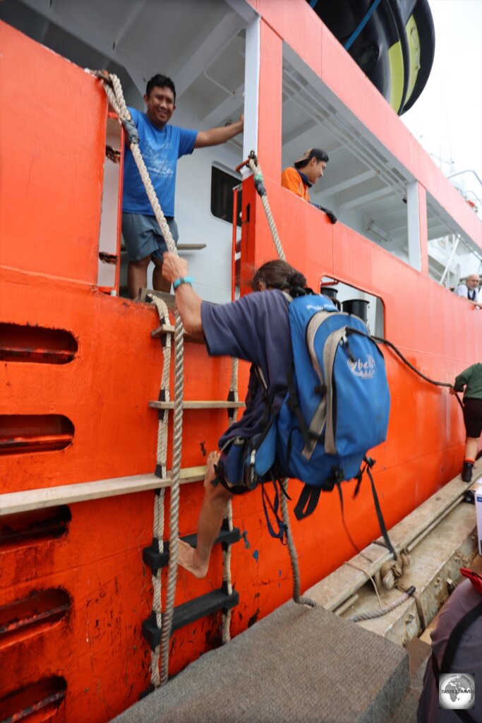 The transfer from the supply ship to the longboat is by way of a rope ladder.