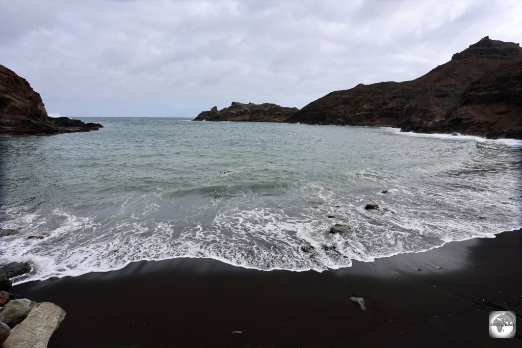 The jet-black volcanic sand beach at Sandy Bay.