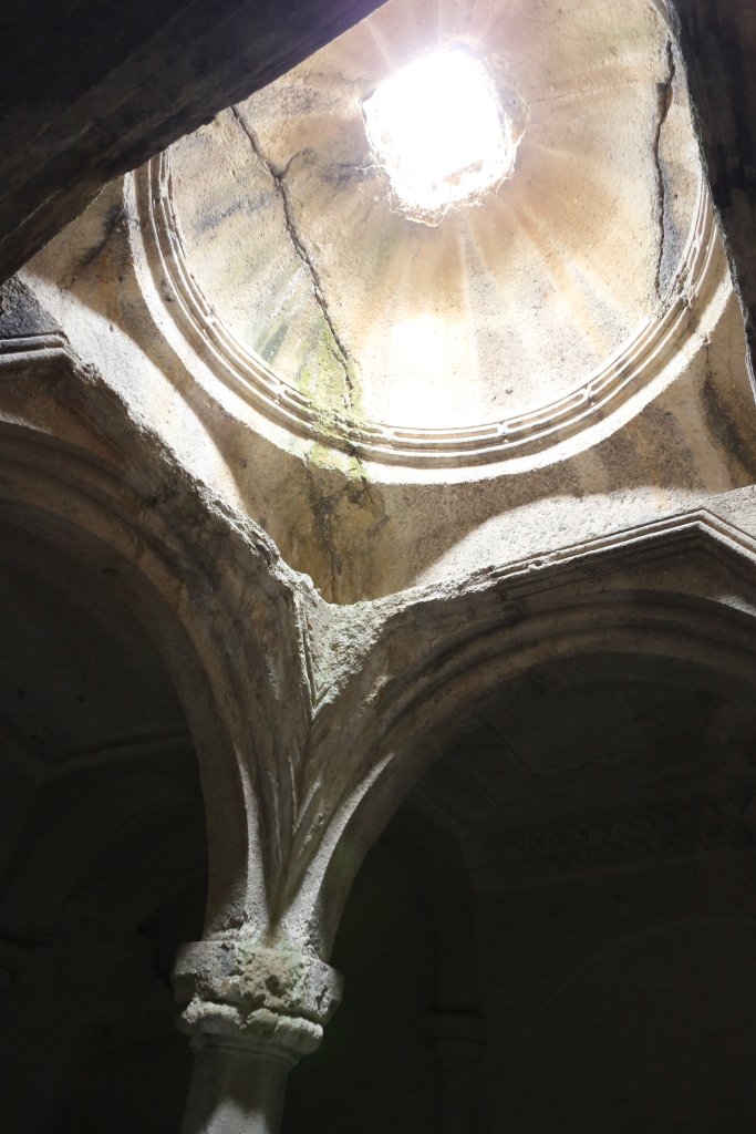 Sunlight enters the rock-hewn Geghard Monastery through an opening in the central dome.
