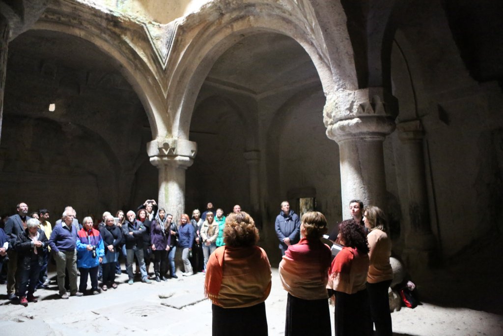 The Geghard Monastery Choir perform, under the central dome, for a tour group.