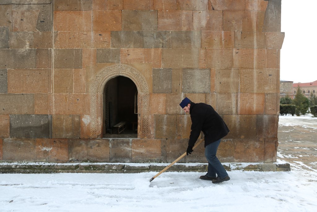 An attendant, shovelling snow outside the Church of Shoghakat in Etchmiadzin.