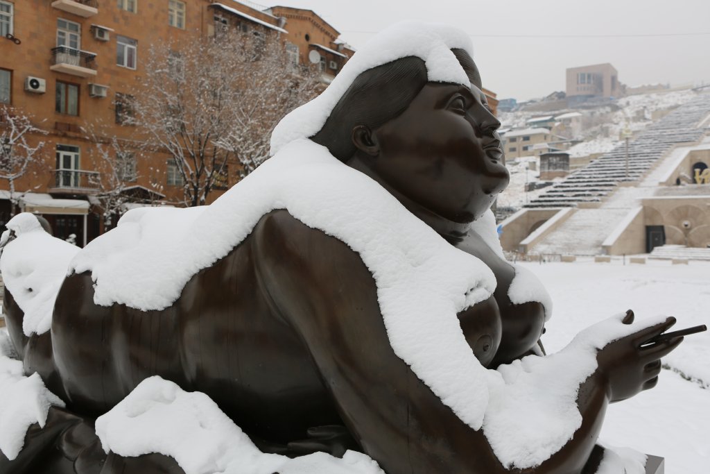 A winter view of "Woman Smoking a Cigarette" by Colombian artist, Fernando Botero, in the Cascade Sculpture Park in Yerevan.