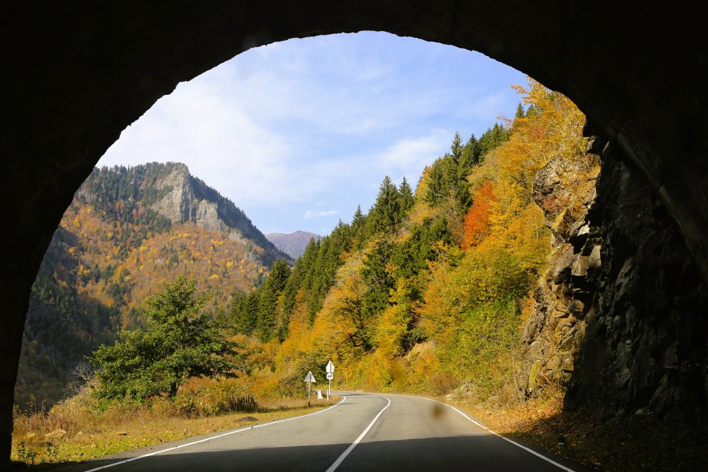 The exit of a road tunnel perfectly frames a beautiful autumn landscape on the road to Svaneti.