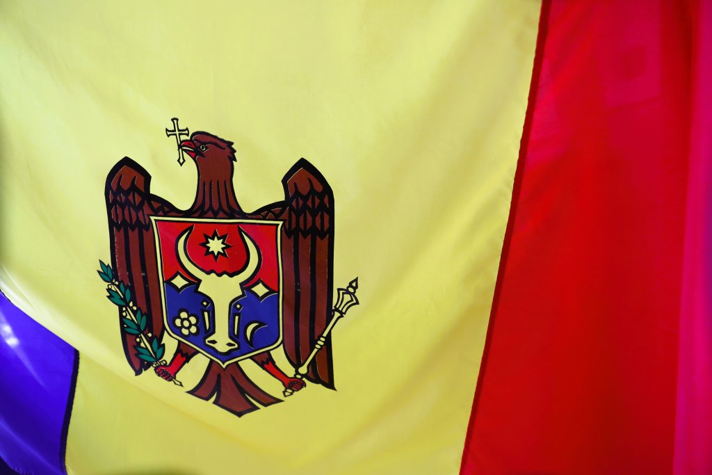 The flag of Moldova features the country's coat of arms, which includes an eagle holding a cross in its beak, for religion, and an olive branch in its claw, for peace.