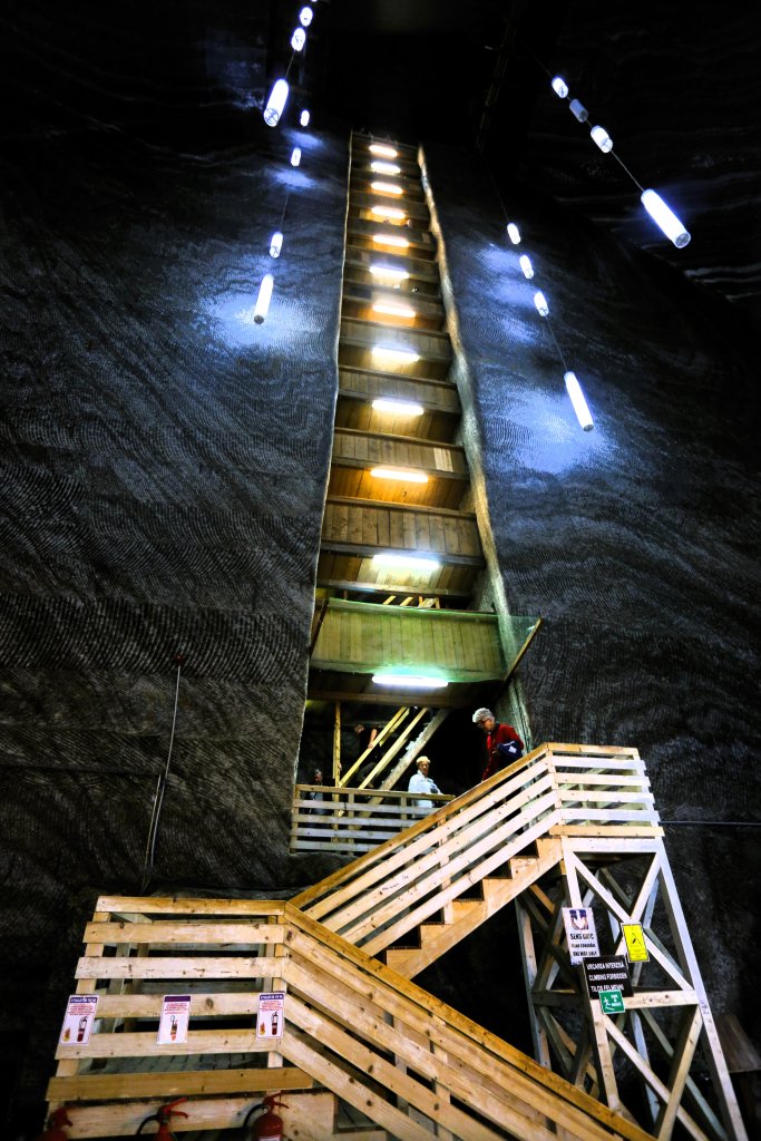A wooden stairway descends down the wall of a chamber into the depths of the Terezia mine (112 metres below ground) where visitors can row a boat on an underground lake.