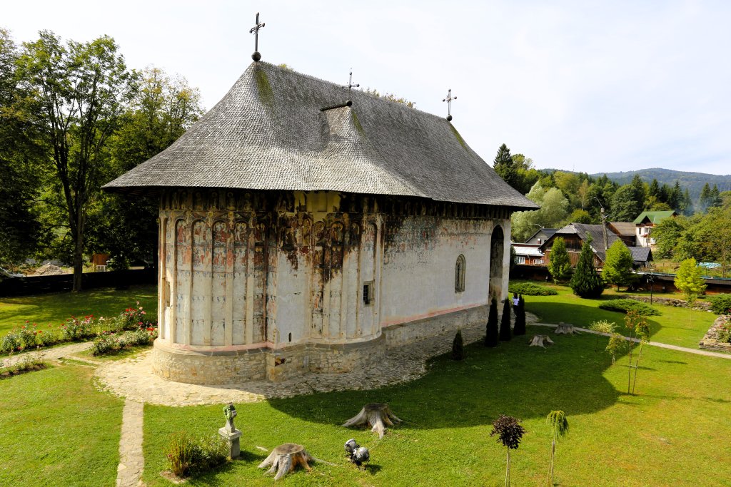 The church at Humorului Monastery, topped by a cross-shaped shingled roof, is without a steeple, indicating that it was commissioned by a court official rather than a prince.